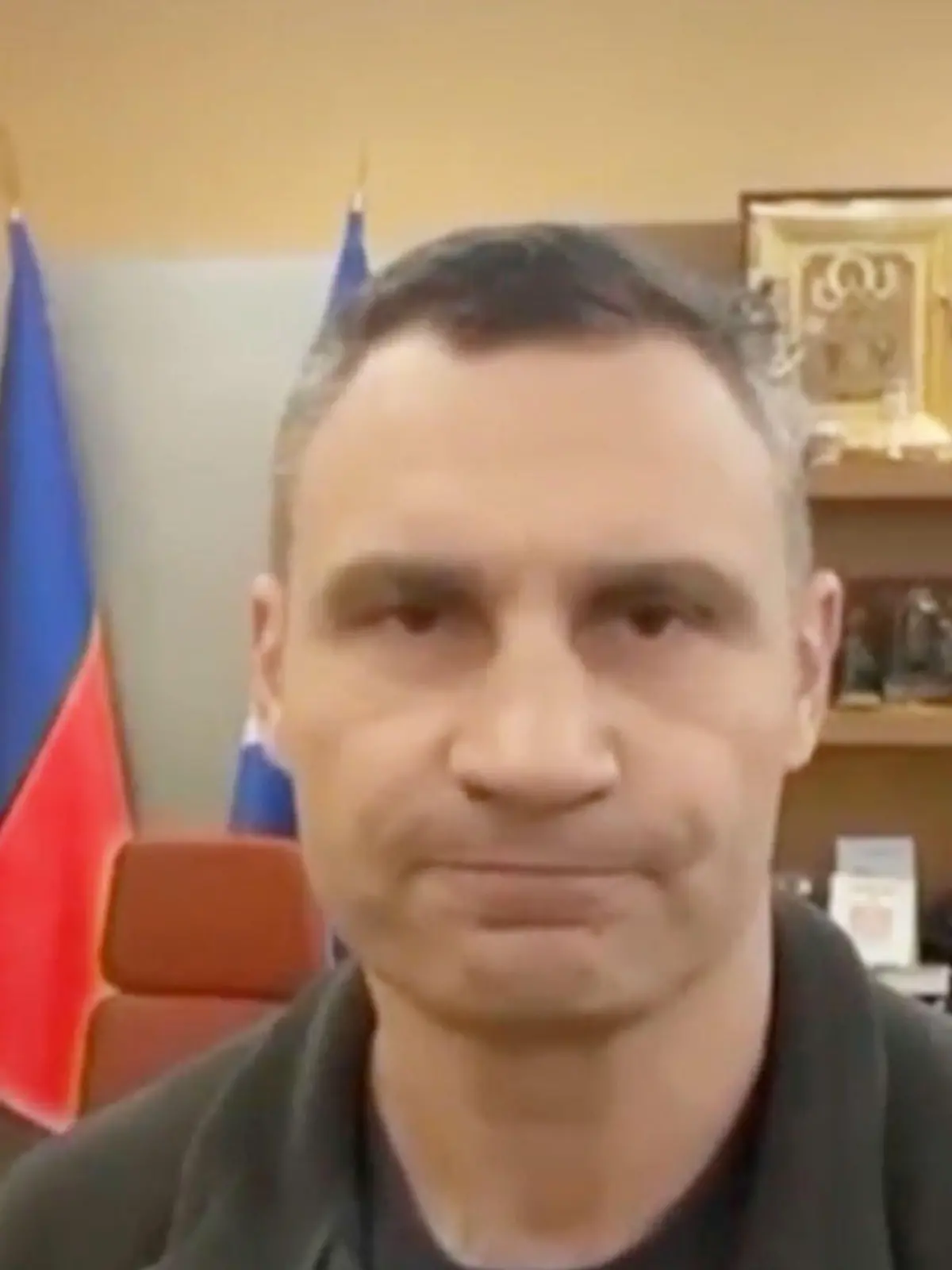 Screenshot aus einem Video, in dem Vitali Klitschko in seinem Büro vor einem Bild von Putin und der russischen Flagge steht.