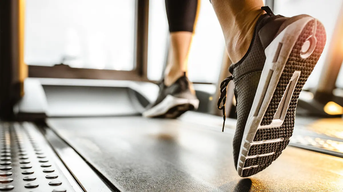 Close up of sole of sneakers of unrecognizable athlete jogging on a treadmill.