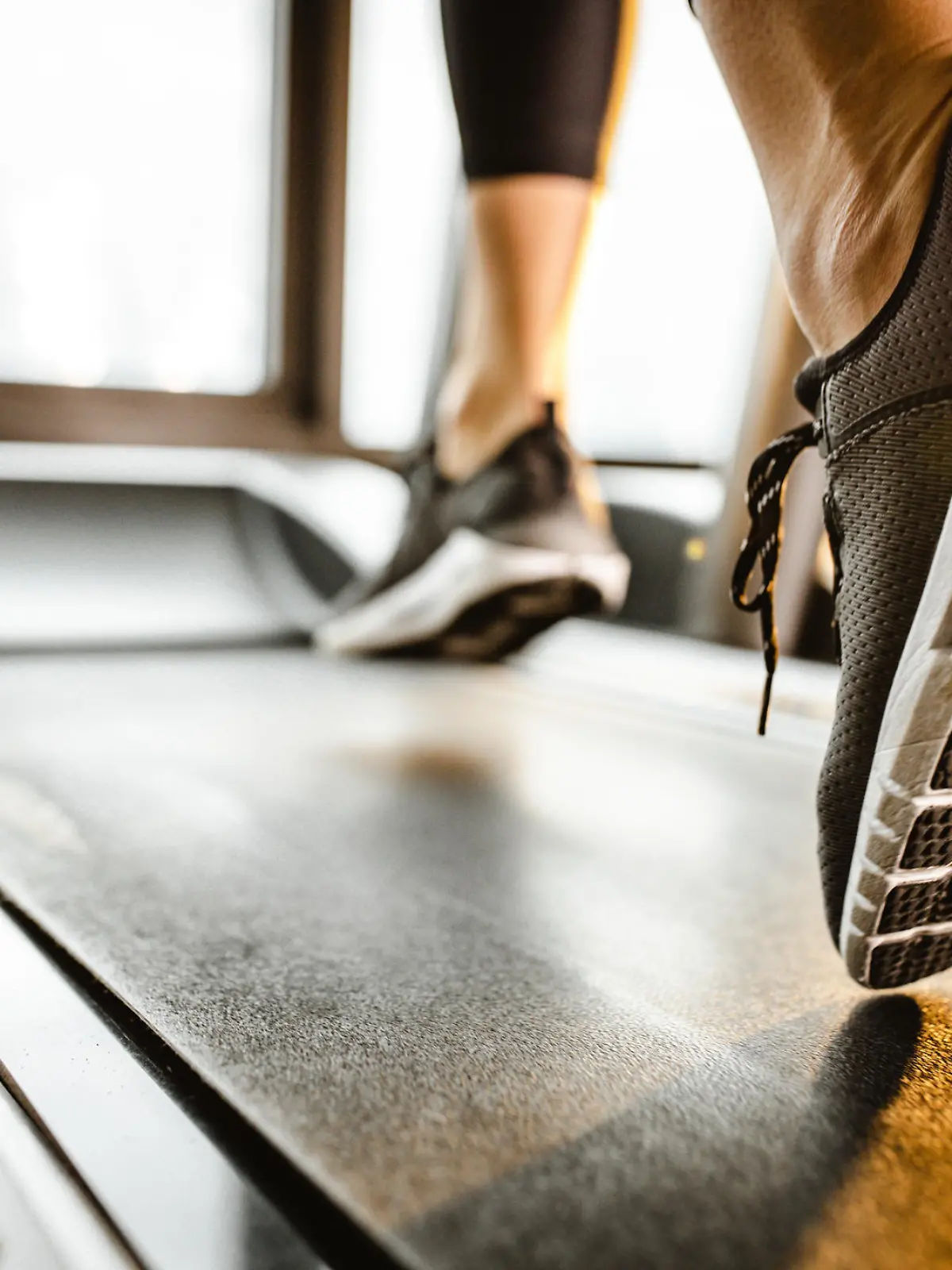 Close up of sole of sneakers of unrecognizable athlete jogging on a treadmill.