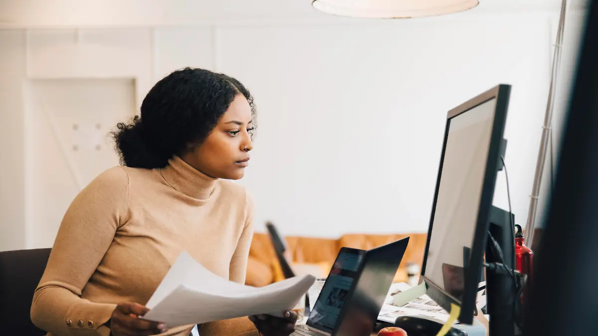 IMAGO Creative, Internationaler Frauenmonat, Entrepreneurinnen IMAGO Creative: Kreative Renaissance -- der junge Entrepreneur  Focused female IT professional holding document while looking at computer in creative office , model released, property released Copyright: xMaskotx , MA72427