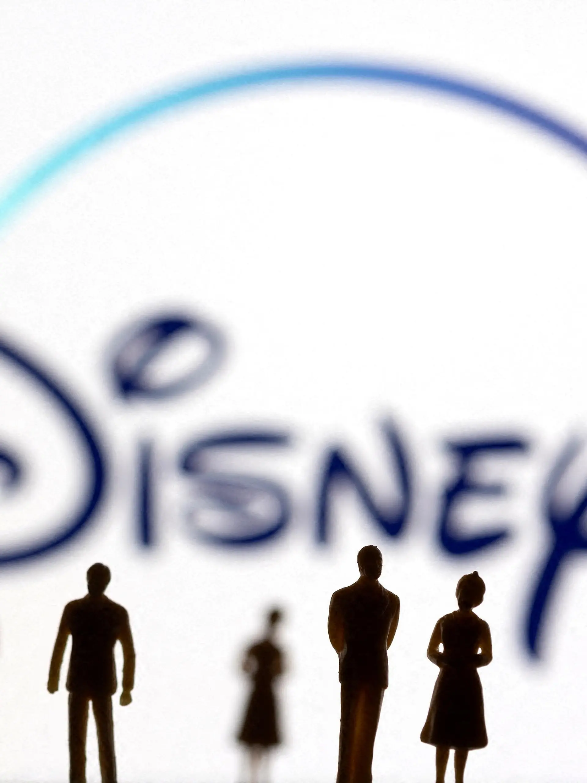 FILE PHOTO: Toy figures of people are seen in front of the displayed Disney + logo, in this illustration taken January 20, 2022. REUTERS/Dado Ruvic/Illustration/File Photo
