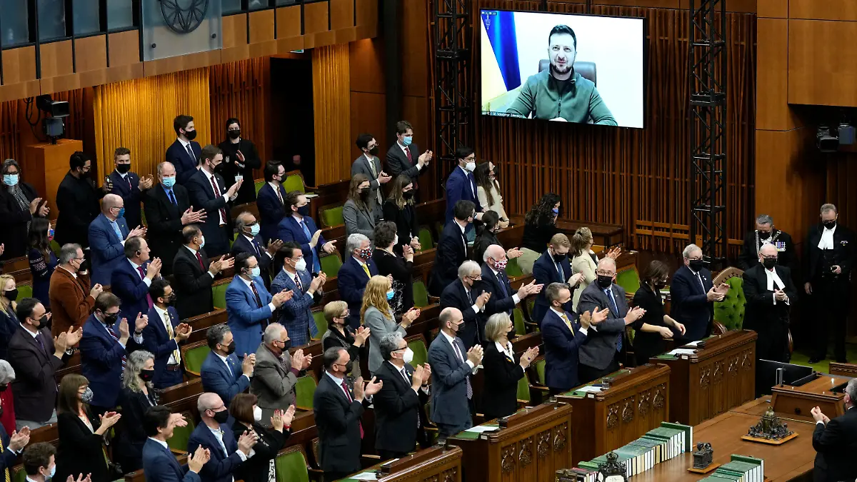 dpatopbilder - 15.03.2022, Kanada, Ottawa: Wolodymyr Selenskyj (Monitor M), Präsident der Ukraine, erhält im Unterhaus auf dem Parliament Hill in Ottawa während seiner Rede per Videokonferenz stehende Beifall. Foto: Adrian Wyld/The Canadian Press/AP/dpa - ACHTUNG: Nur zur redaktionellen Verwendung und nur mit vollständiger Nennung des vorstehenden Credits +++ dpa-Bildfunk +++