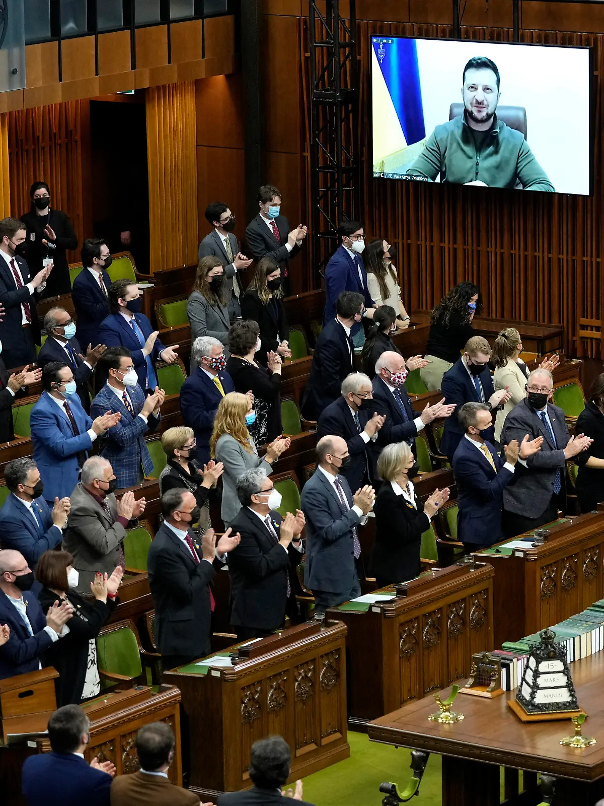 dpatopbilder - 15.03.2022, Kanada, Ottawa: Wolodymyr Selenskyj (Monitor M), Präsident der Ukraine, erhält im Unterhaus auf dem Parliament Hill in Ottawa während seiner Rede per Videokonferenz stehende Beifall. Foto: Adrian Wyld/The Canadian Press/AP/dpa - ACHTUNG: Nur zur redaktionellen Verwendung und nur mit vollständiger Nennung des vorstehenden Credits +++ dpa-Bildfunk +++