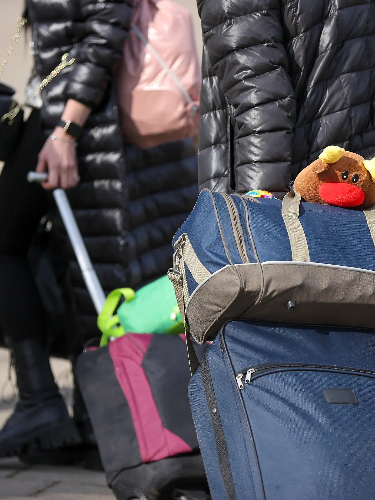 16.03.2022, Sachsen, Leipzig: Aus der Ukraine geflüchtete Menschen gehen in eine Erstaufnahmeeinrichtung auf der Leipziger Messe. In Sachsen sollen in den kommenden Tagen etwa 10 000 Plätze in zentralen Einrichtungen für Flüchtlinge eingerichtet werden. Insgesamt werden nach vorsichtigen Schätzungen 80 000 Geflüchtete im Freistaat eine vorübergehende Heimat finden. Foto: Jan Woitas/dpa-Zentralbild/dpa +++ dpa-Bildfunk +++
