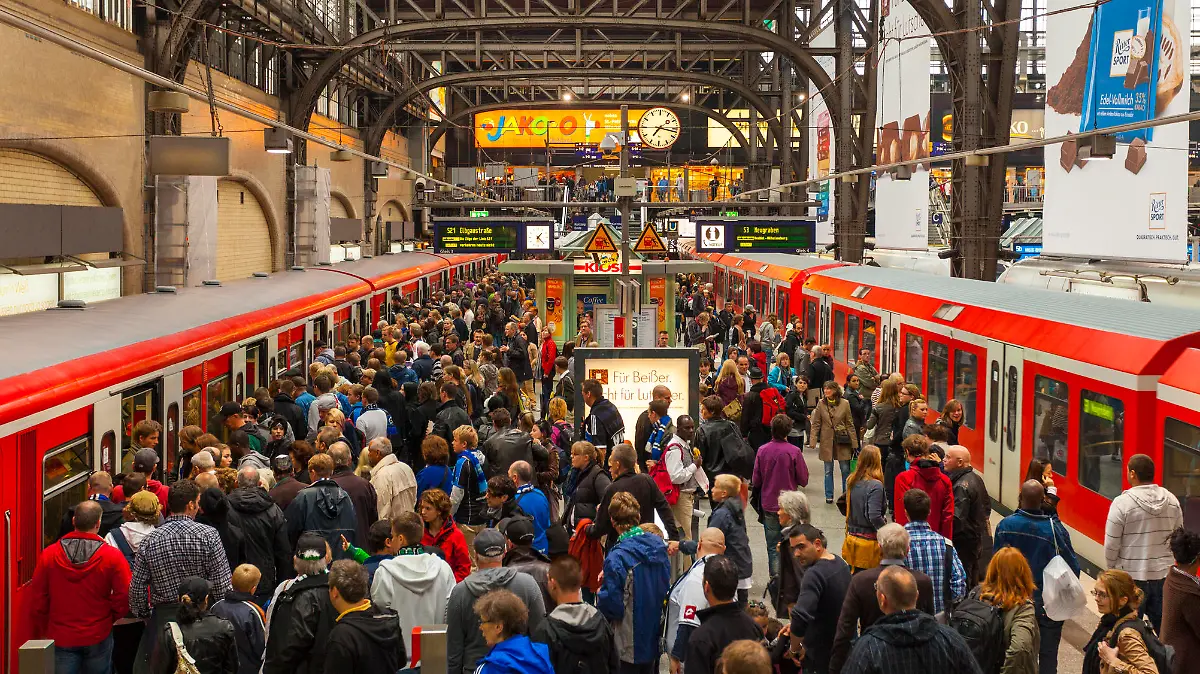 "Hamburg, Germany - September 17, 2011: Crowded station platform of the Hamburg S-Bahn at the Hamburg hauptbahnhof. Many people can be seen on the platform, some of which can be seen wearing scarves and blue jerseys to support a local football team."