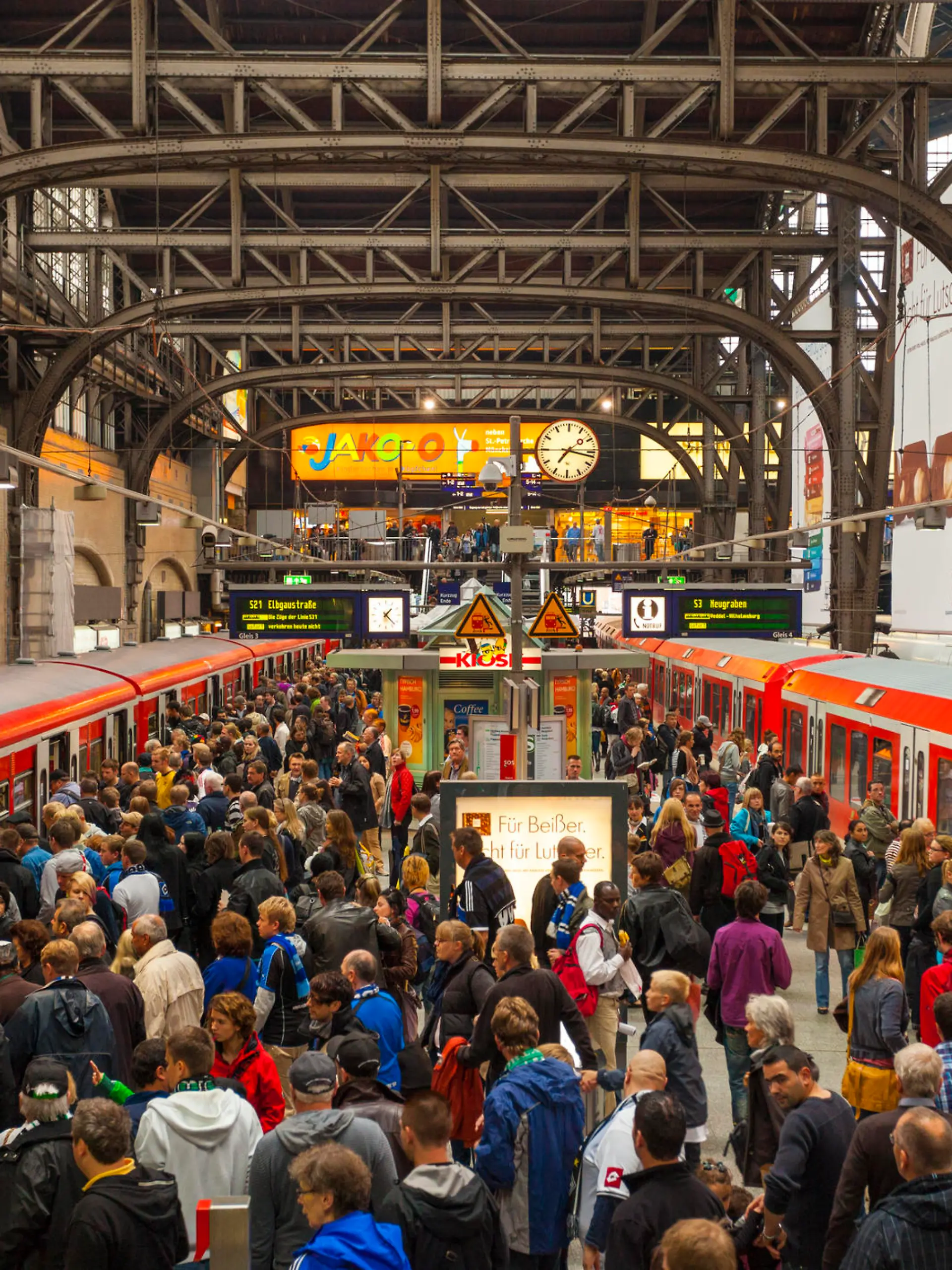 "Hamburg, Germany - September 17, 2011: Crowded station platform of the Hamburg S-Bahn at the Hamburg hauptbahnhof. Many people can be seen on the platform, some of which can be seen wearing scarves and blue jerseys to support a local football team."