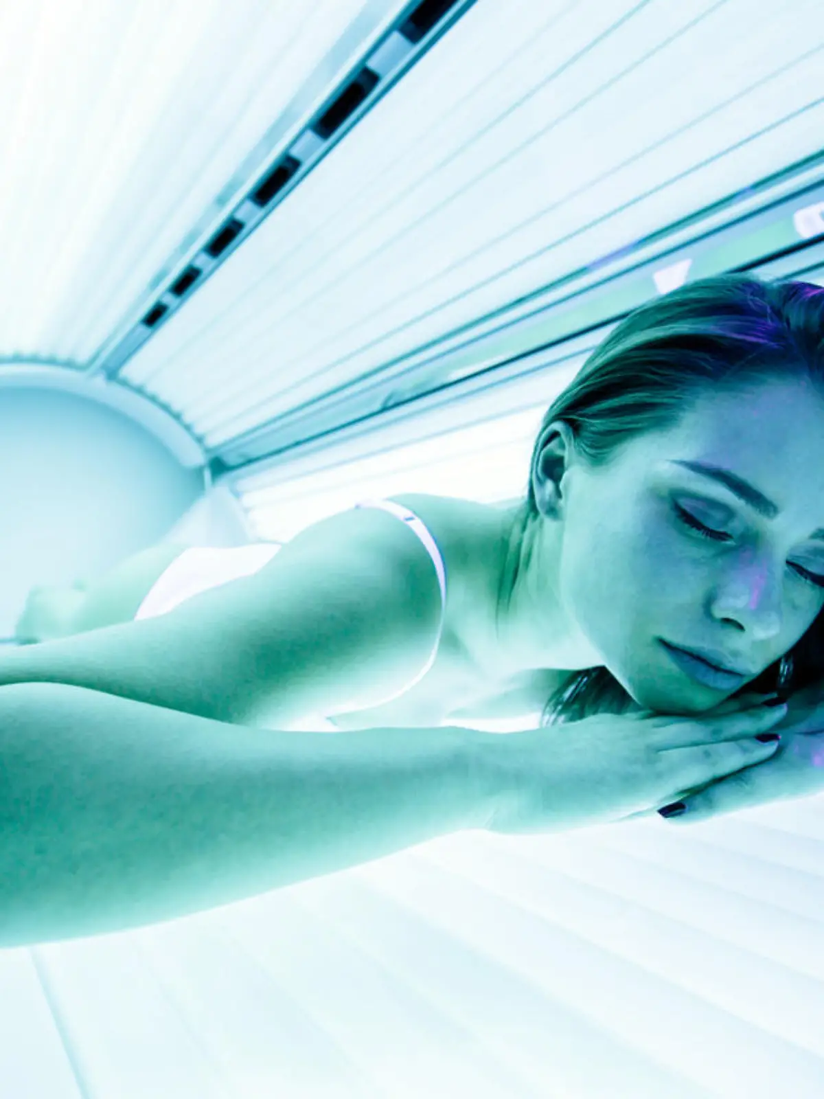 Beautiful sexy brunette woman sunbathing in solarium