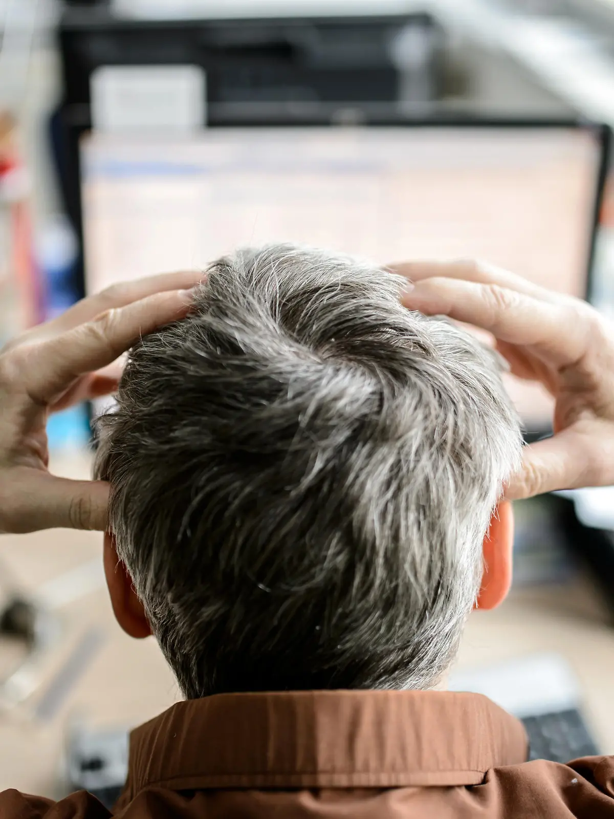 Illustration - Ein Angestellter sitzt in einem Büro vor seinem Computer und rauft sich die Haare, aufgenommen am 04.02.2015 in Dresden (Sachsen). Foto: Thomas Eisenhuth/dpa