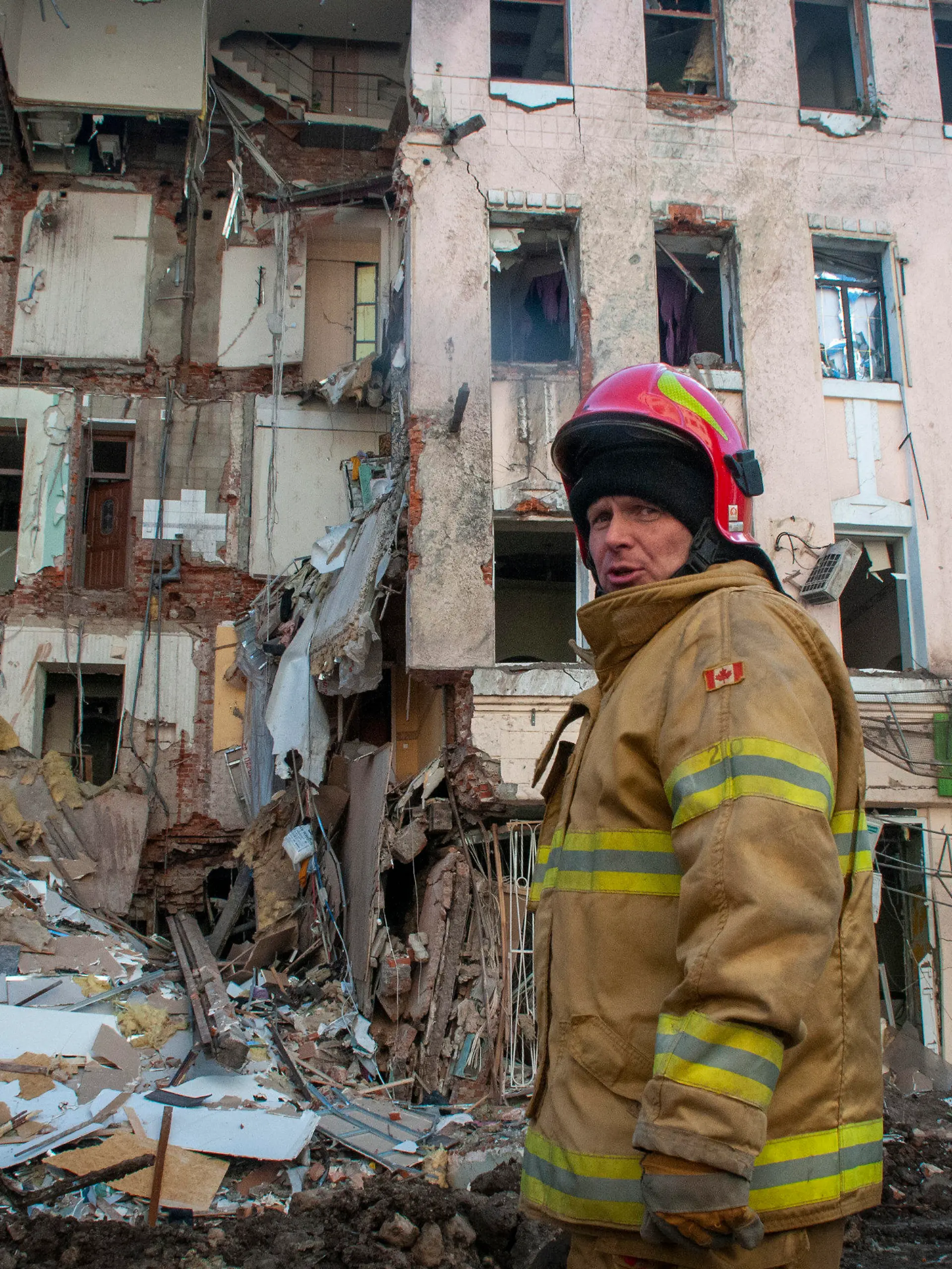 16.03.2022, Ukraine, Charkiw: Ein ukrainischer Feuerwehrmann steht vor einem zerstörten Wohnhaus. Sowohl Russland als auch die Ukraine gaben sich vor einer weiteren geplanten Gesprächsrunde optimistisch, auch wenn Moskaus Streitkräfte Kiew und andere Großstädte unter Beschuss nahmen, um den Widerstand zu brechen, der die Hoffnungen des Kremls auf einen Blitzsieg zunichte gemacht hat.Photo/Andrew Marienko) Foto: Andrew Marienko/AP/dpa +++ dpa-Bildfunk +++
