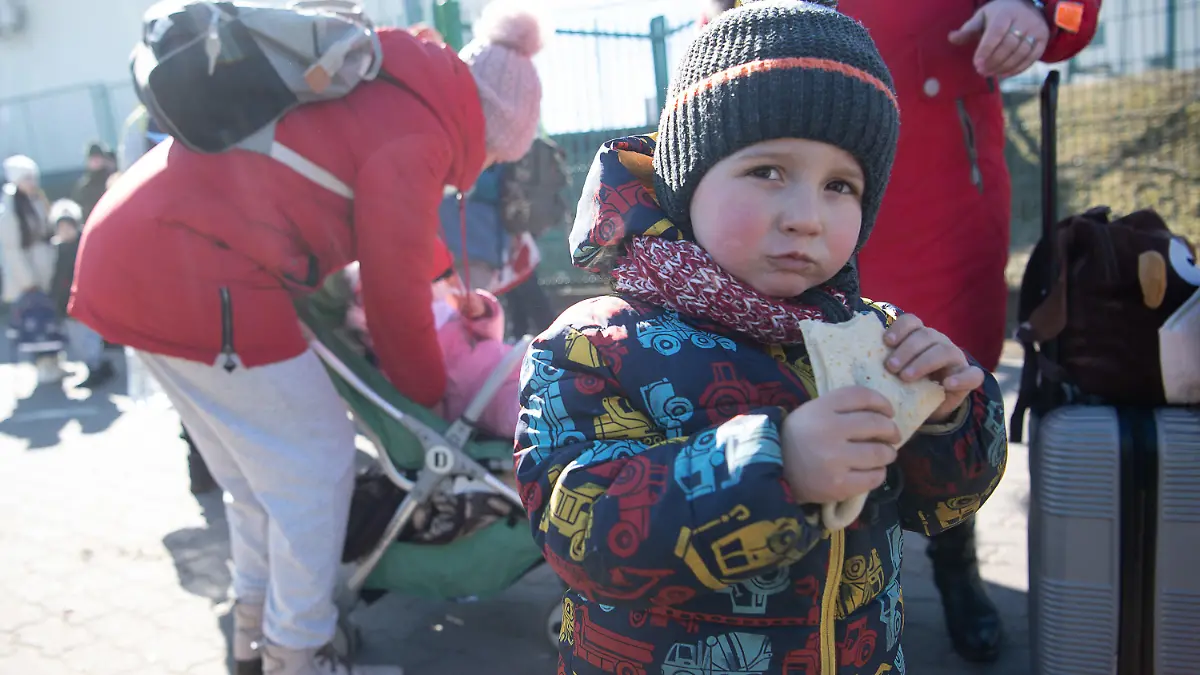 11.03.2022, Polen, Medyka: Matwej, der mit seiner Mutter und Großmutter aus Charkiw in der Ukraine geflohen ist, steht mit einem Crepe in der Hand kurz hinter dem Grenzübergang von der Ukraine nach Polen. Russische Truppen marschierten am 24. Februar 2022 in die Ukraine ein. (zu dpa Helfer an Polens Grenze: «An meiner Schulter kannst du weinen») Foto: Sebastian Gollnow/dpa +++ dpa-Bildfunk +++