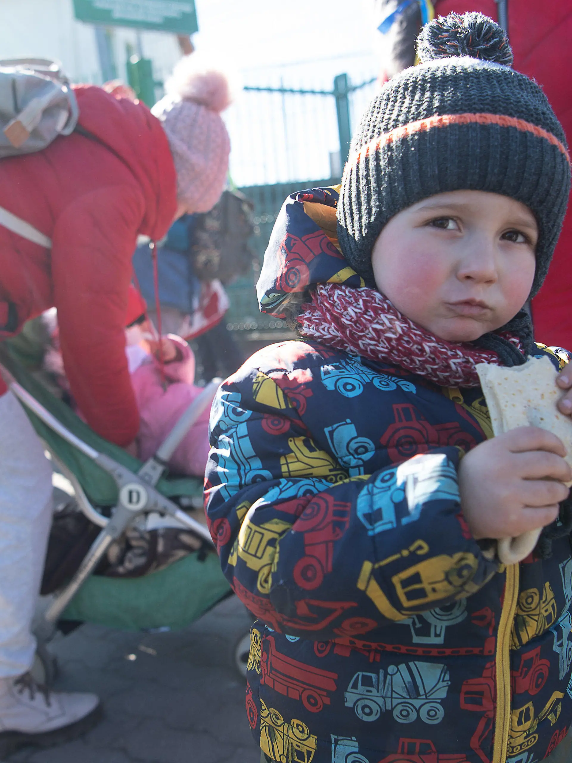 11.03.2022, Polen, Medyka: Matwej, der mit seiner Mutter und Großmutter aus Charkiw in der Ukraine geflohen ist, steht mit einem Crepe in der Hand kurz hinter dem Grenzübergang von der Ukraine nach Polen. Russische Truppen marschierten am 24. Februar 2022 in die Ukraine ein. (zu dpa Helfer an Polens Grenze: «An meiner Schulter kannst du weinen») Foto: Sebastian Gollnow/dpa +++ dpa-Bildfunk +++