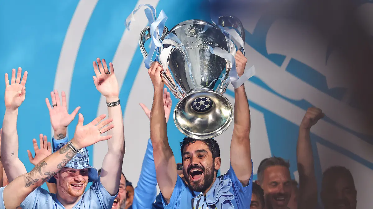 12.06.2023, Großbritannien, Manchester: Ilkay Gündogan (M) von Manchester City jubelt mit dem Pokal der Champions League auf der Bühne nach der Siegesparade anlässlich des Gewinns der Premier League, des FA-Cups und der Champions League. Manchester City hat gegen Inter Mailand in Istanbul den Gewinn der Champions League gesichert. Foto: Mark Cosgrove/News Images via ZUMA Press Wire/dpa - ACHTUNG: Nur zur redaktionellen Verwendung im Zusammenhang mit der aktuellen Berichterstattung und nur mit vollständiger Nennung des vorstehenden Credits +++ dpa-Bildfunk +++