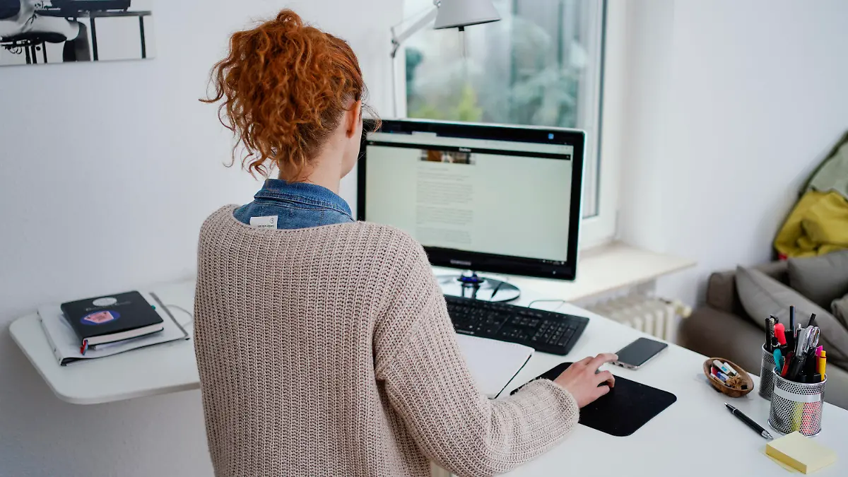 ARCHIV - 22.01.2021, Baden-Württemberg, Mannheim: Eine Frau arbeitet in ihrer Wohnung vor einem Computer an einem Stehtisch. (zu dpa "Eigener Schreibtisch in Gefahr - Tücken für Unternehmen") Foto: Uwe Anspach/dpa +++ dpa-Bildfunk +++