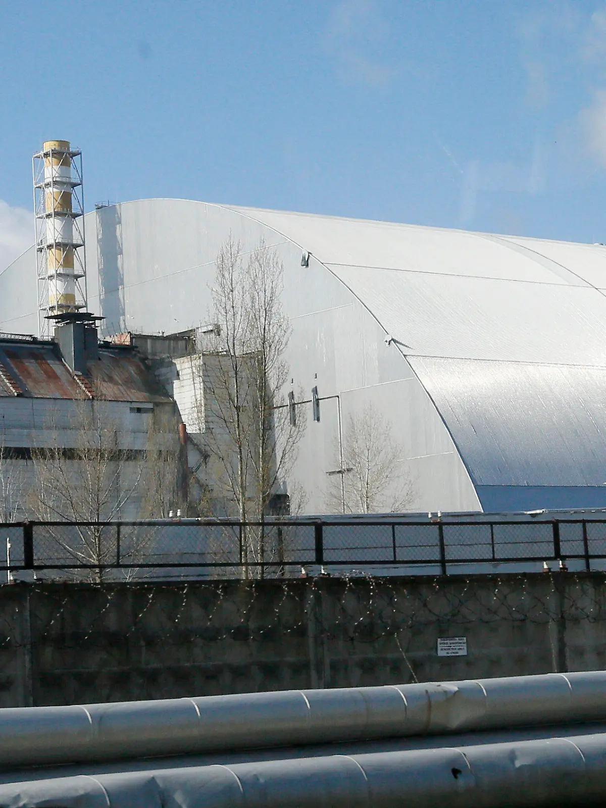 ARCHIV - 27.04.2021, Ukraine, Tschernobyl: Ein Schutzbau bedeckt den explodierten Reaktor im Kernkraftwerk Tschernobyl. Russische und ukrainische Truppen liefern sich nach Angaben des ukrainischen Präsidenten Wolodymyr Selenskyj am Donnerstag (24.02.2022) auch Gefechte in der Nähe des ehemaligen Atomkraftwerks Tschernobyl. Foto: Efrem Lukatsky/AP/dpa +++ dpa-Bildfunk +++