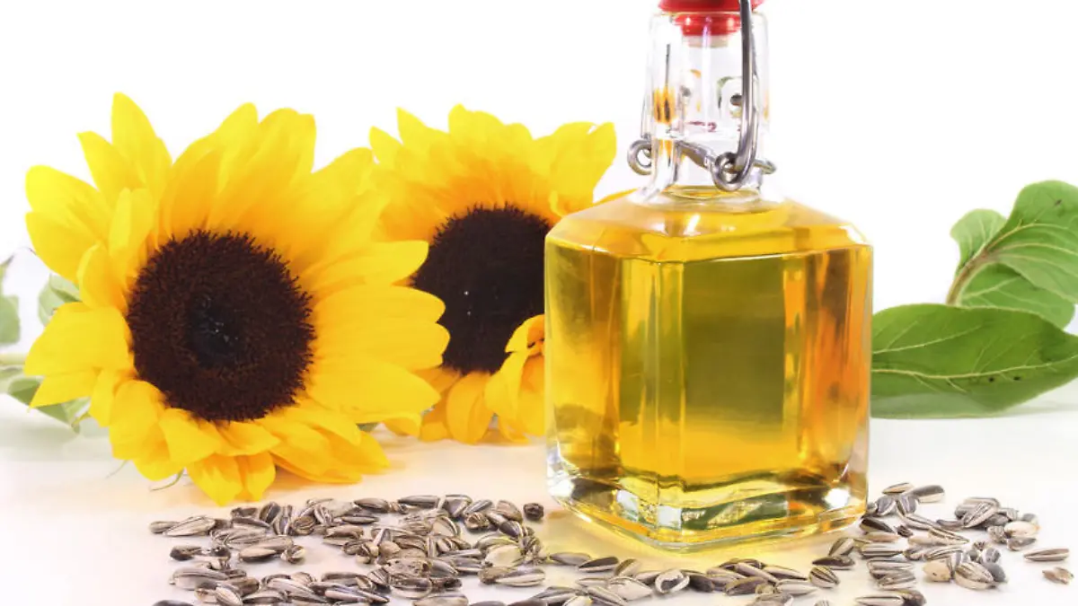 eine Flasche Sonnenblumenöl mit Sonnenblumen