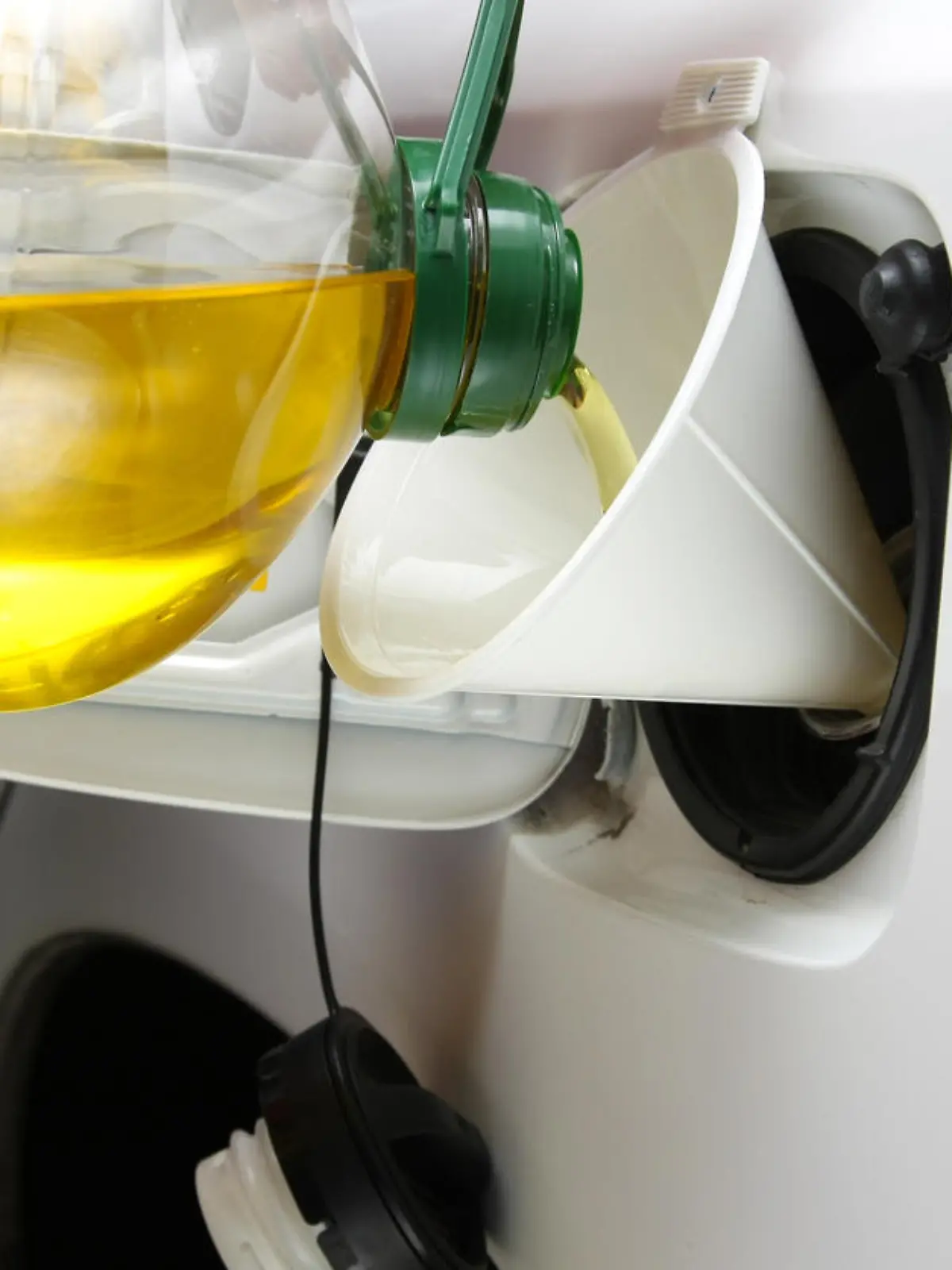Using vegetable oil as an alternative fuel source for automobiles.  Vegetable oil being poured into an SUV's gas tank.Please visit my lightbox for more similar photos