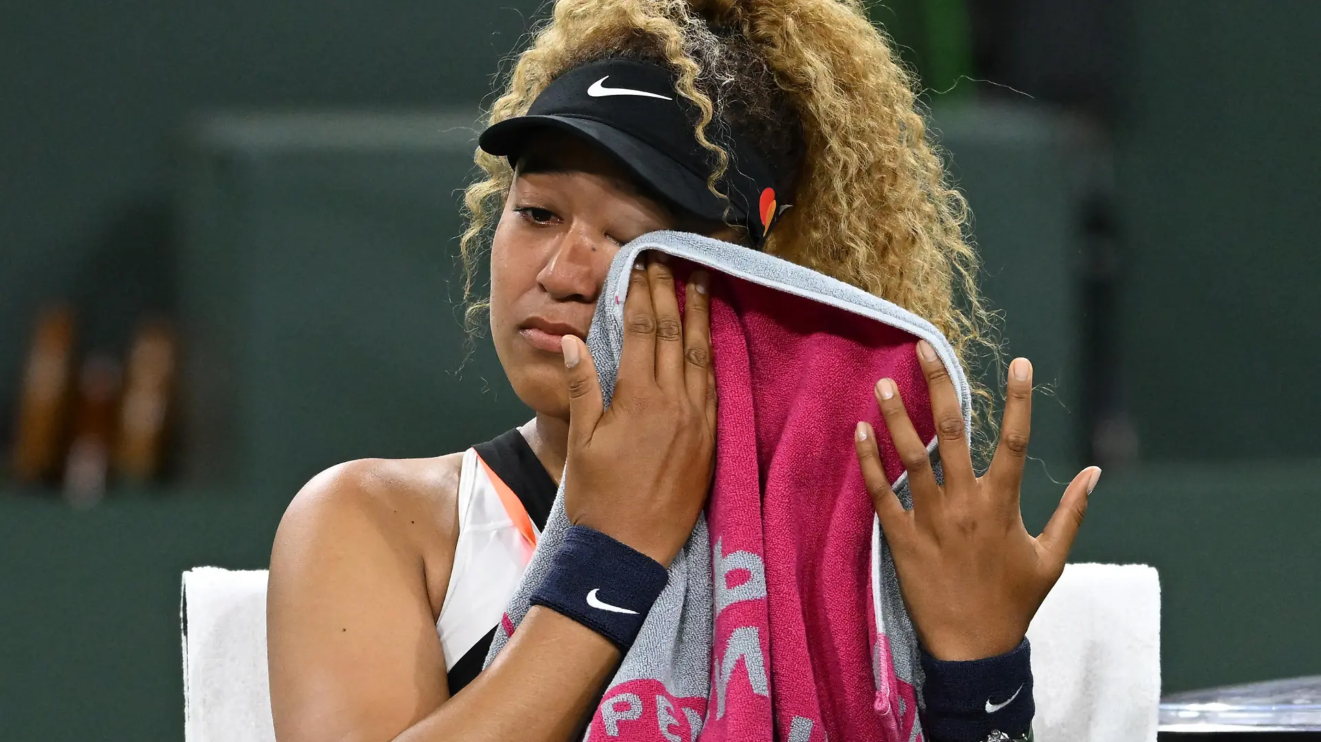Mar 12, 2022; Indian Wells, CA, USA; Naomi Osaka (JPN) wipes her face as she talks to referee Claire Wood after a spectator disrupted play, yelling Naomi you suck, before the start of her 2nd round match against Veronika Kudermetova (RUS) at the BNP Paribas open at the Indian Wells Tennis Garden. Mandatory Credit: Jayne Kamin-Oncea-USA TODAY Sports
