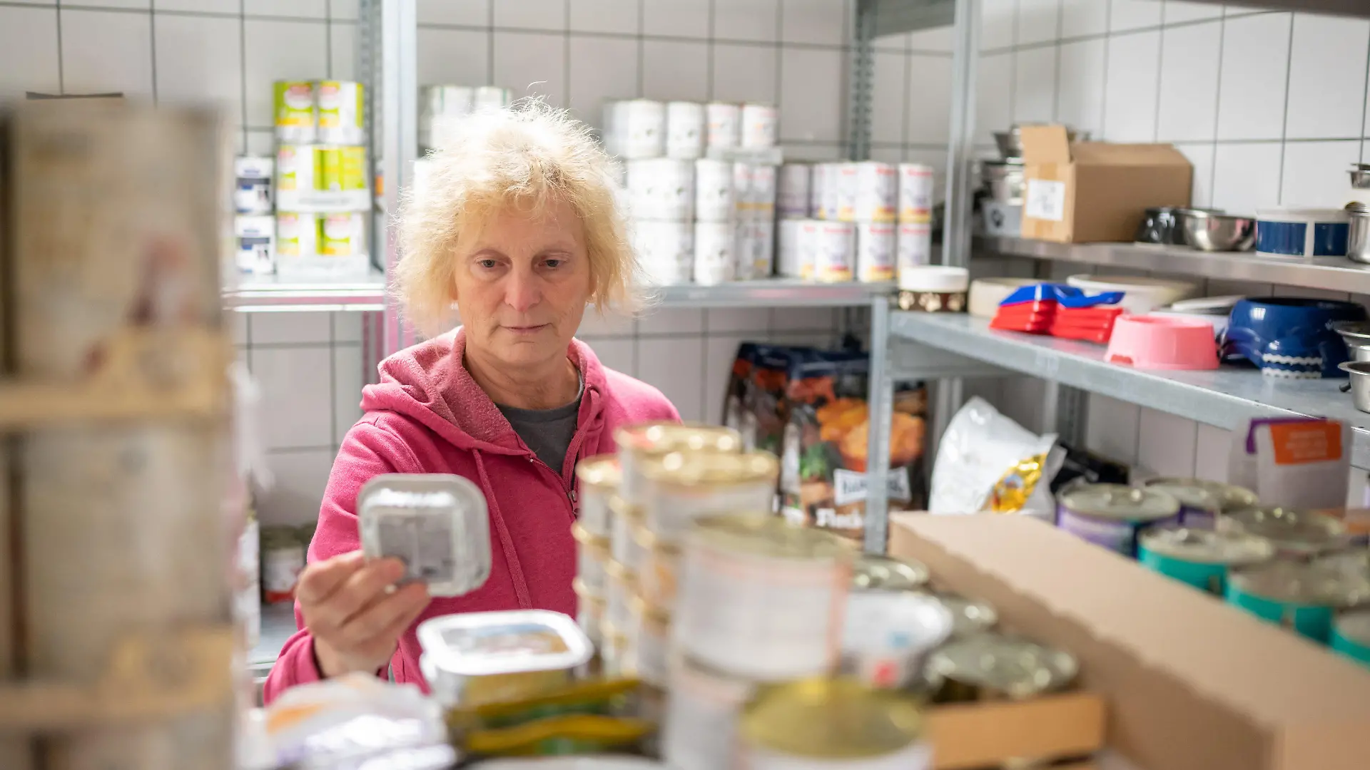 PRODUKTION - 02.03.2022, Niedersachsen, Neu Wulmstorf: Doris Firlus, Betreiberin des Tierzentrums Neu Wulmstorf, kontrolliert die Tiernahrung. Wo früher Affen und Hunde Höllenqualen leiden mussten, bekommen Vierbeiner nun ein neues Zuhause. Aus dem geschlossenen Versuchslabor in Mienenbüttel wird ein Heim für vernachlässigte Tiere. (zu dpa Tierheim statt Versuchslabor - Tierschützer arbeiten ehrenamtlich mit) Foto: Philipp Schulze/dpa +++ dpa-Bildfunk +++