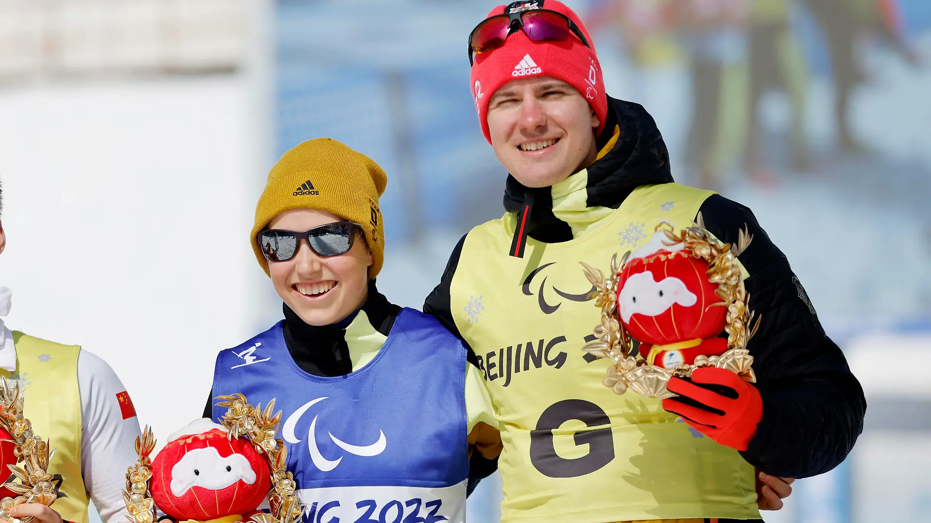 Beijing 2022 Winter Paralympic Games - Para Cross-Country Skiing - Women's Middle Distance Free Technique Vision Impaired - National Biathlon Centre, Zhangjiakou, China - March 12, 2022. Gold medallist Linn Kazmaier of Germany with guide Florian Baumann of Germany hold awards depicting Shuey Rhon Rhon, the mascot of the Beijing 2022 Winter Paralympic Olympics, during the flower ceremony. REUTERS/Issei Kato