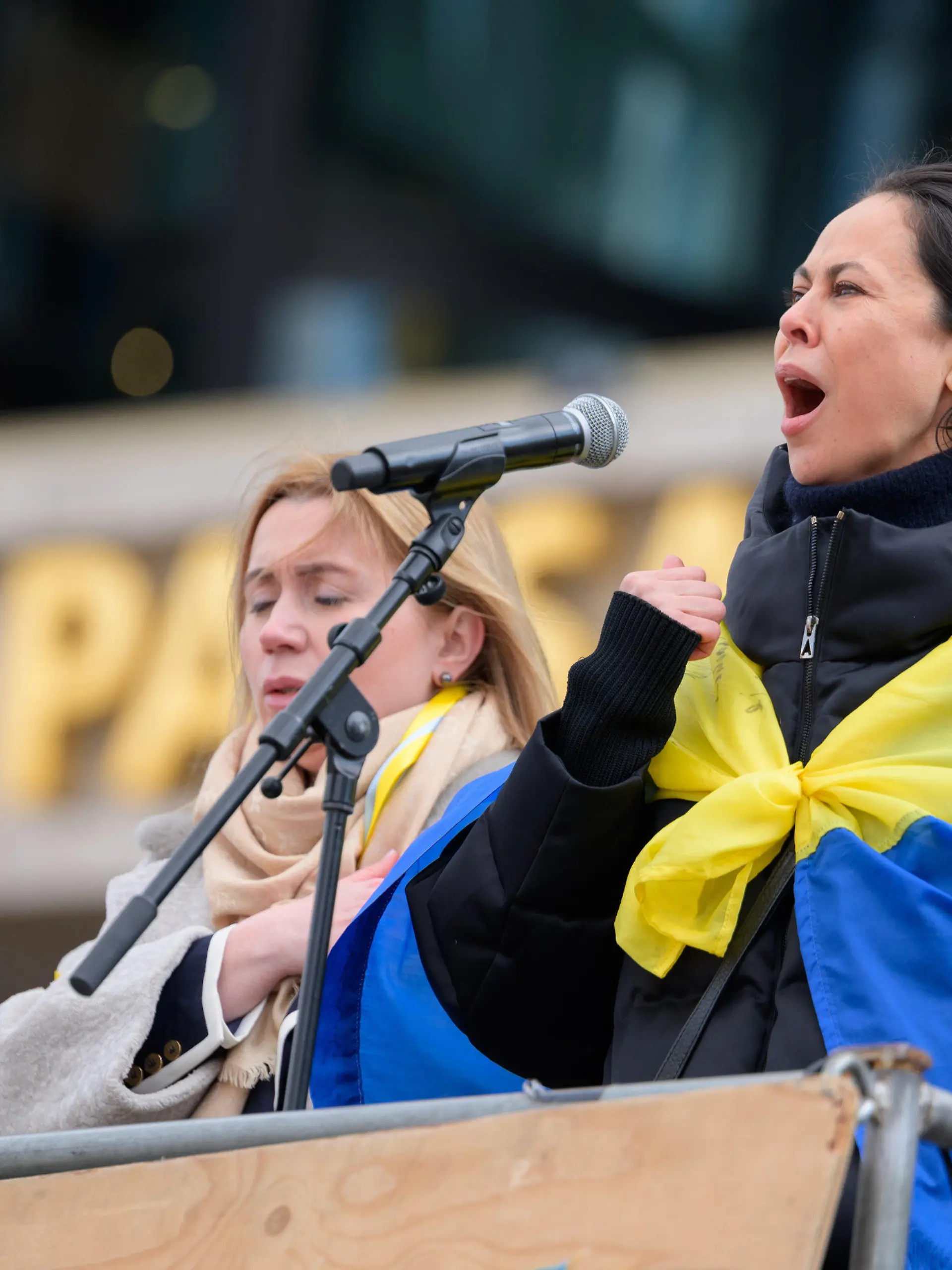05.03.2022, Hamburg: Natalia Klitschko (r) singt mit Iryna Tybinka (l), Generalkonsulin der Ukraine in Hamburg, die ukrainische Nationalhymne bei der Auftaktkundgebung vor der Europa Passage am Jungfernstieg. Unterstützt von zahlreichen Jugendorganisationen, Parteien, Gewerkschaften und zivilgesellschaftlichen Organisationen hat die Ukrainische Diaspora zu einer Großdemonstration unter dem Motto «Frieden in der Ukraine und Sicherheit in Europa» in der Innenstadt aufgerufen. Foto: Jonas Walzberg/dpa +++ dpa-Bildfunk +++