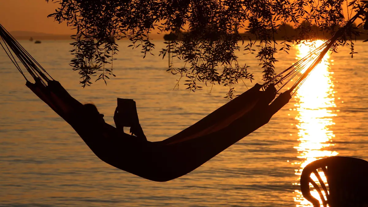 Eine Frau liest am Samstag (20.08.2011) in einer Hängematte am Badestrand eines Campingplatzes in Lindau (Schwaben) ein Buch. Ideales Strand- und Badewetter herrscht derzeit am Bodensee. Die Temperaturen steigen bis auf 32 Grad. Foto: Karl-Josef Hildenbrand dpa/lby/lsw +++(c) dpa - Bildfunk+++