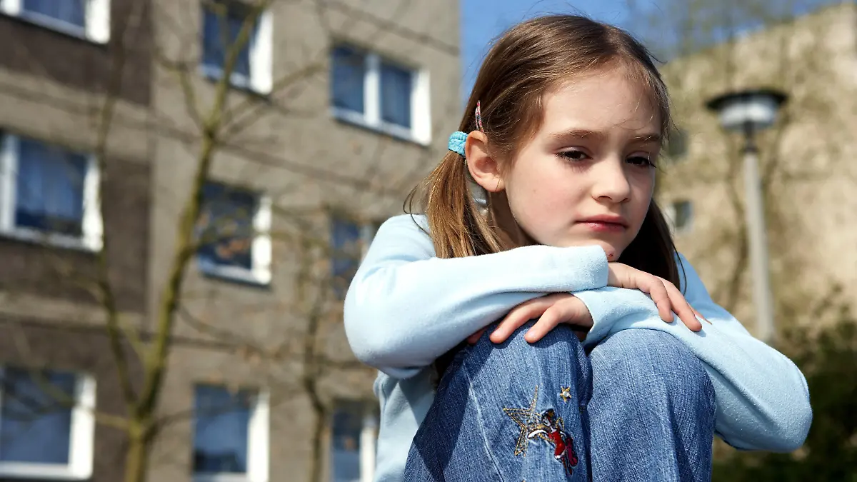 Ein kleines Mädchen sitzt allein in einem Neubaugebiet in Ostdeutschland (gestelltes Illustrationsfoto zum Thema Kindheit, Einsamkeit, Wohnen vom 20.04.2006) . Foto: Jörg Lange +++(c) dpa - Report+++