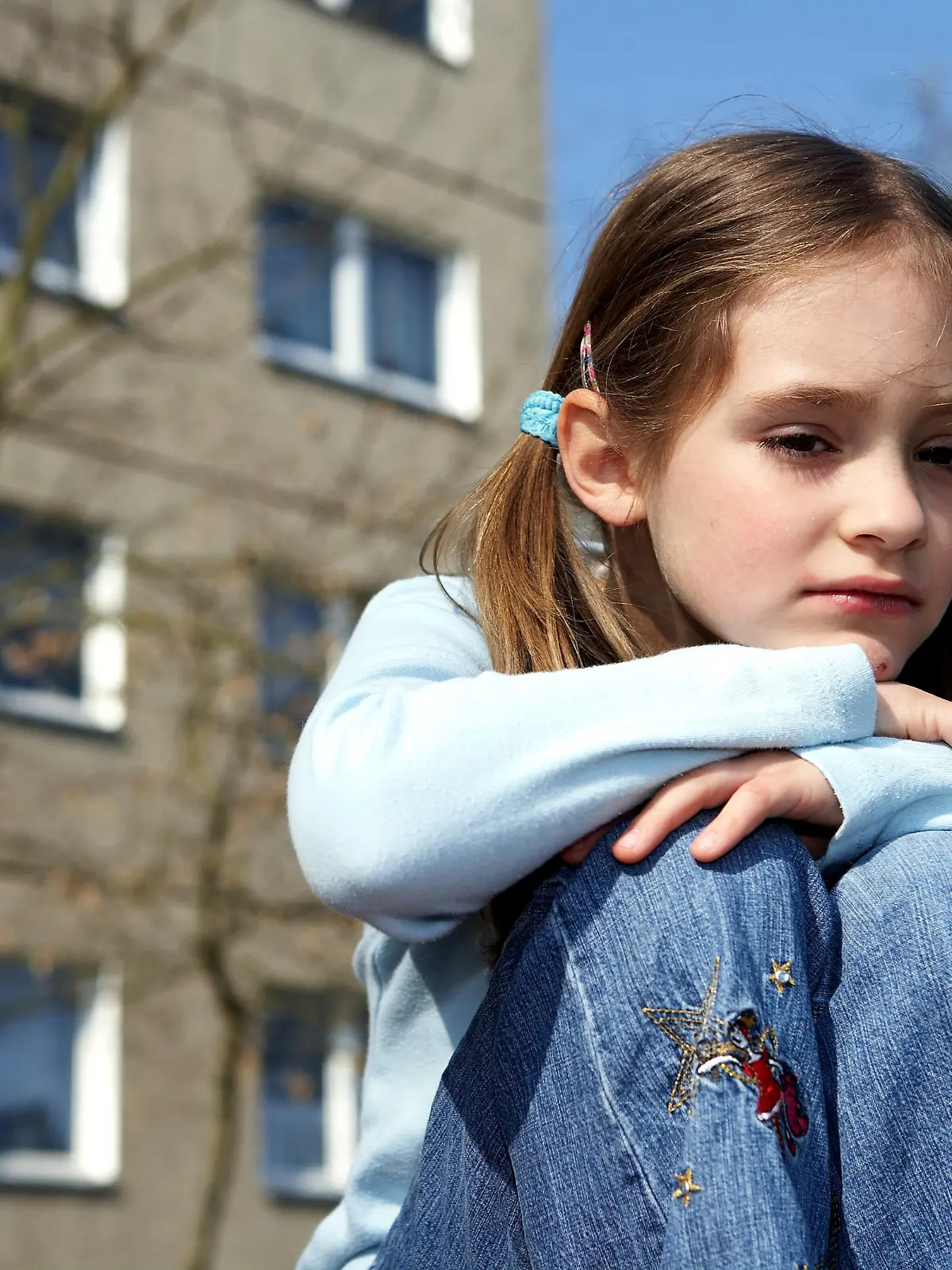 Ein kleines Mädchen sitzt allein in einem Neubaugebiet in Ostdeutschland (gestelltes Illustrationsfoto zum Thema Kindheit, Einsamkeit, Wohnen vom 20.04.2006) . Foto: Jörg Lange +++(c) dpa - Report+++