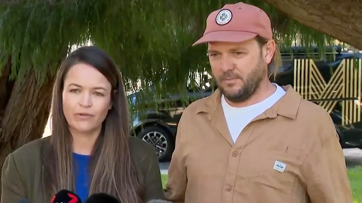In this image made from video provided by CH7 AUS, Samantha Moran, left, standing next to her husband Tobias, speaks in front of media members in Perth, Australia, Wednesday, June 14, 2023. Australian prosecutors have dropped a murder charge against German immigrant Tobias Moran over the death of his German backpacker girlfriend Simone Strobel in 2005. (CH7 AUS via AP)