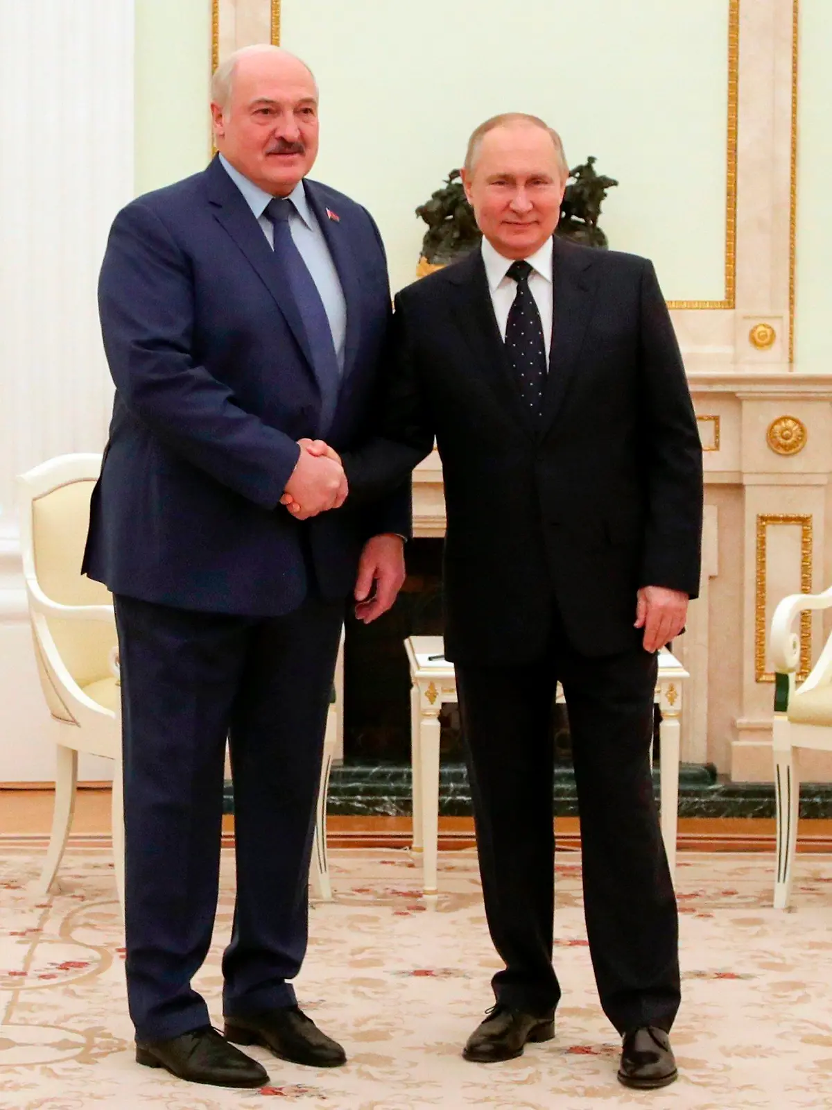 HANDOUT - 11.03.2022, Russland, Moskau: Das von der staatlichen russischen Nachrichtenagentur Sputnik veröffentlichte und von der Nachrichtenagentur AP zur Verfügung gestellte Handout-Bild zeigt Alexander Lukaschenko (l), Präsident von Belarus, und Wladimir Putin, Präsident von Russland, die sich im Rahmen eines Treffens die Hand geben. Foto: Mikhail Klimentyev/Pool Sputnik Kremlin/AP/dpa +++ dpa-Bildfunk +++