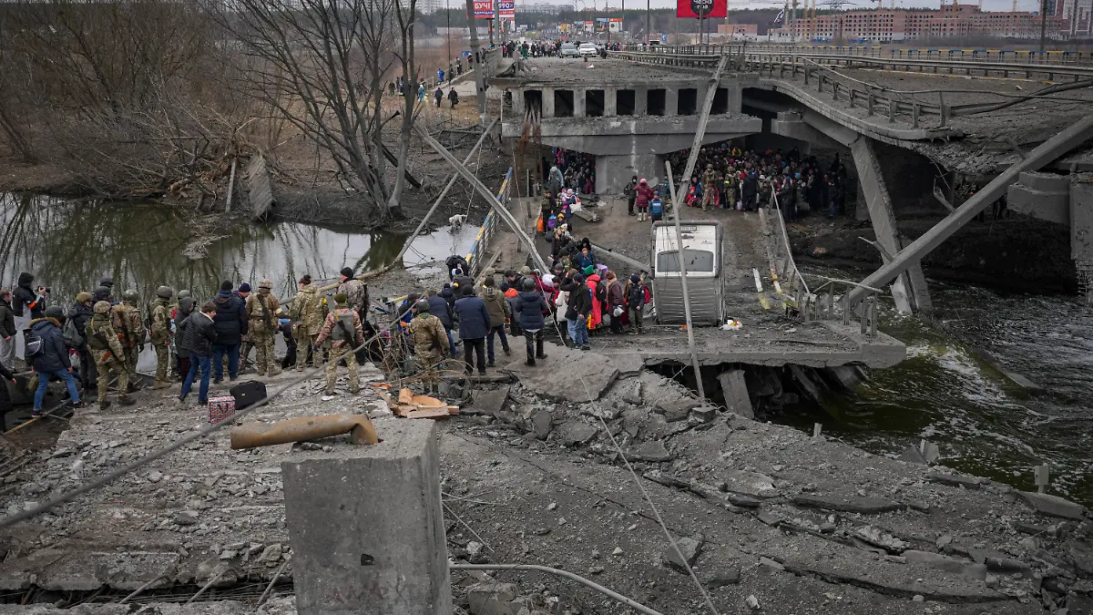 People cross the Irpin river on an improvised path under a bridge, that was destroyed by Ukrainian troops designed to slow any Russian military advance, while fleeing the town of Irpin, Ukraine, Saturday, March 5, 2022. What looked like a breakthrough cease-fire to evacuate residents from two cities in Ukraine quickly fell apart Saturday as Ukrainian officials said shelling had halted the work to remove civilians hours after Russia announced the deal. (AP Photo/Vadim Ghirda)