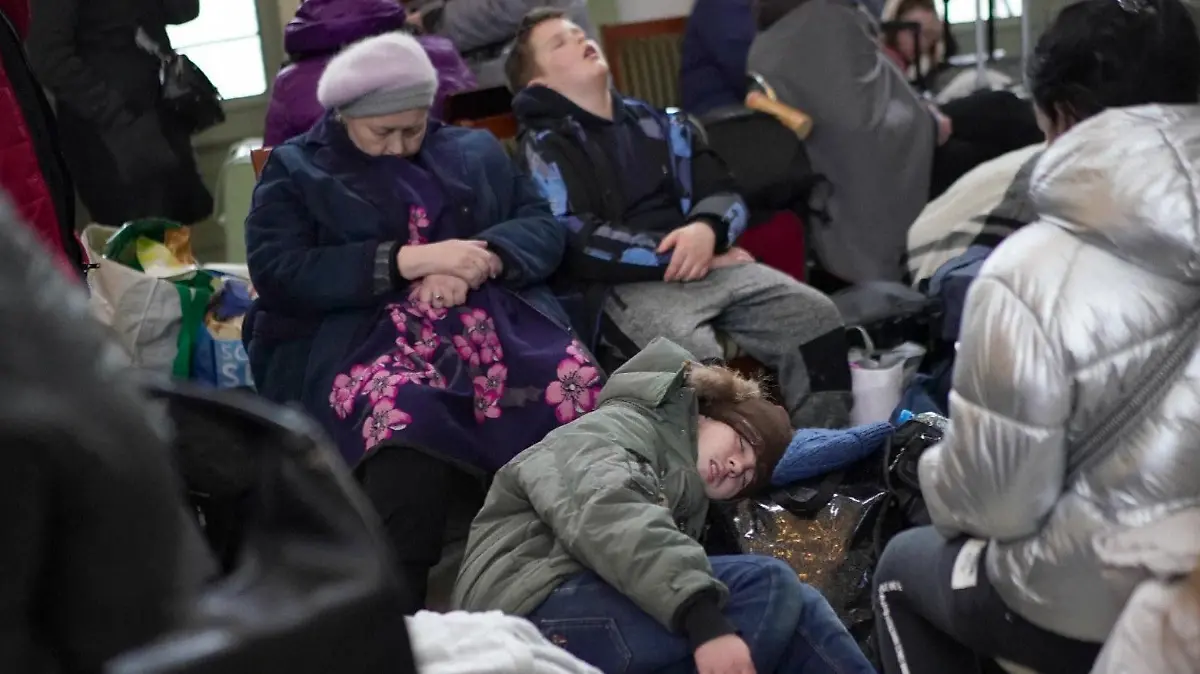 Erschöpfte Menschen schlafen am Bahnhof.