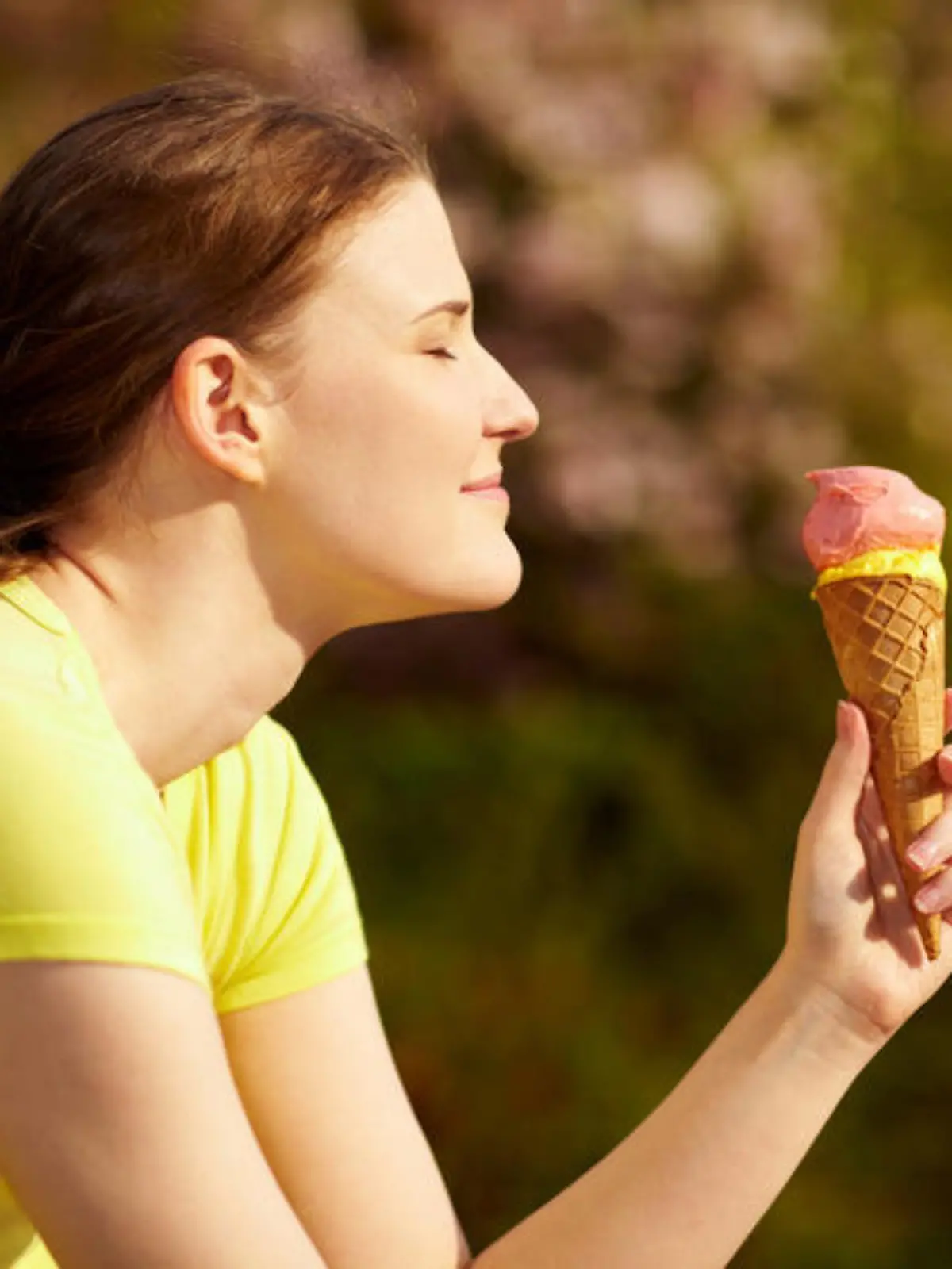 Lachende Frau isst Eiscreme in der Waffel im Sommer