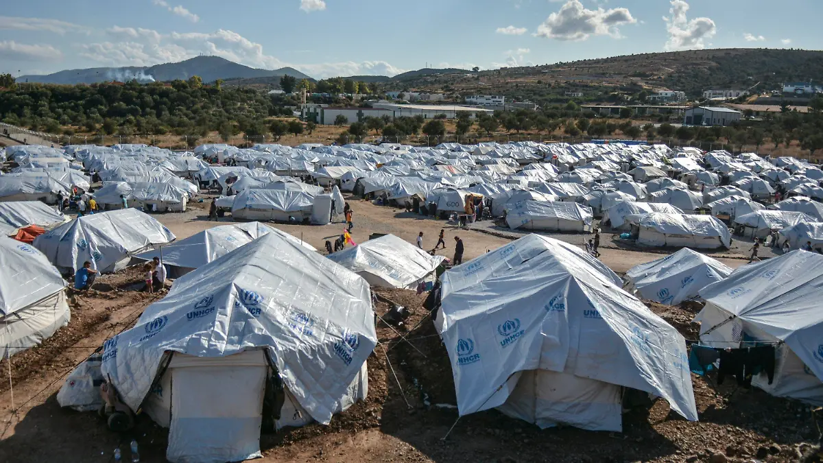ARCHIV - 14.10.2020, Griechenland, Lesbos: Migranten gehen nach starken Regenfällen durch das Flüchtlingslager «Kara Tepe». Das provisorische Zeltlager «Kara Tepe» war in Windeseile errichtet worden, nachdem das ursprüngliche Lager Moria bei einem Großbrand fast völlig zerstört worden war. (zu dpa "Flüchtlingslager auf Lesbos: Matsch, Krätze, Hoffnungslosigkeit") Foto: Panagiotis Balaskas/AP/dpa +++ dpa-Bildfunk +++