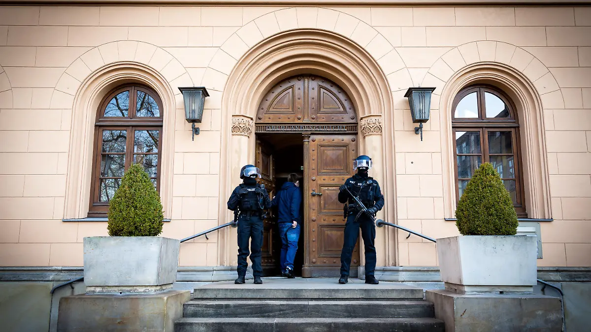 09.03.2022, Niedersachsen, Celle: Polizisten sichern einen Eingang zum Oberlandesgericht. Dort beginnt der Prozess gegen eine Angeklagte, die 2014 gemeinsam mit einer 16-Jährigen nach Syrien ausgereist sein soll und sich dort der terroristischen Vereinigung «Islamischer Staat» (IS) angeschlossen haben soll. Ihre damals vier Jahre alte Tochter soll die Angeklagte gegen den Willen des Kindsvaters mitgenommen haben. In Syrien habe sie nacheinander mehrere IS-Mitglieder nach islamischem Ritus geheiratet. Foto: Moritz Frankenberg/dpa +++ dpa-Bildfunk +++
