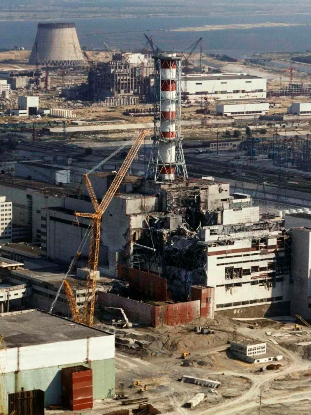 Reparaturarbeiten am explodierten ukrainischen Atomkraftwerk Tschernobyl (Aufnahme vom 1. Oktober 1986). Im Vordergrund der zerstörte Reaktorblock 4, in dem sich am 26. April 1986 eine Explosion ereignete, die zum weltweit schwerstenReaktorunfall führte. Nach Schätzungen wurden rund 600000 Menschen einer starken Strahlenbelastung ausgesetzt, unter den Bergungsmannschaften gab es angeblich 7000 Tote. 125000 Helfer sind nach Informationen der WHO schwer erkrankt. Wegen der Gefährdung durch Radioaktivität mußten 375000 Menschen umgesiedelt werden. 15 Jahre nach der Atomkatastrophe von Tschernobyl soll der Unglücksreaktor eine neue und dauerhafte Stahlhülle erhalten. Dies sieht eine Vereinbarung zwischen der Regierung der Ukraine und der Osteuropabank (EBWE) vor. Eine Sprecherin der Bank sagte am 24.4.2001 in London, Kiew habe zwar das grundsätzliche Einverständnis zu dem Konzept bekundet.  [dpabilderarchiv]