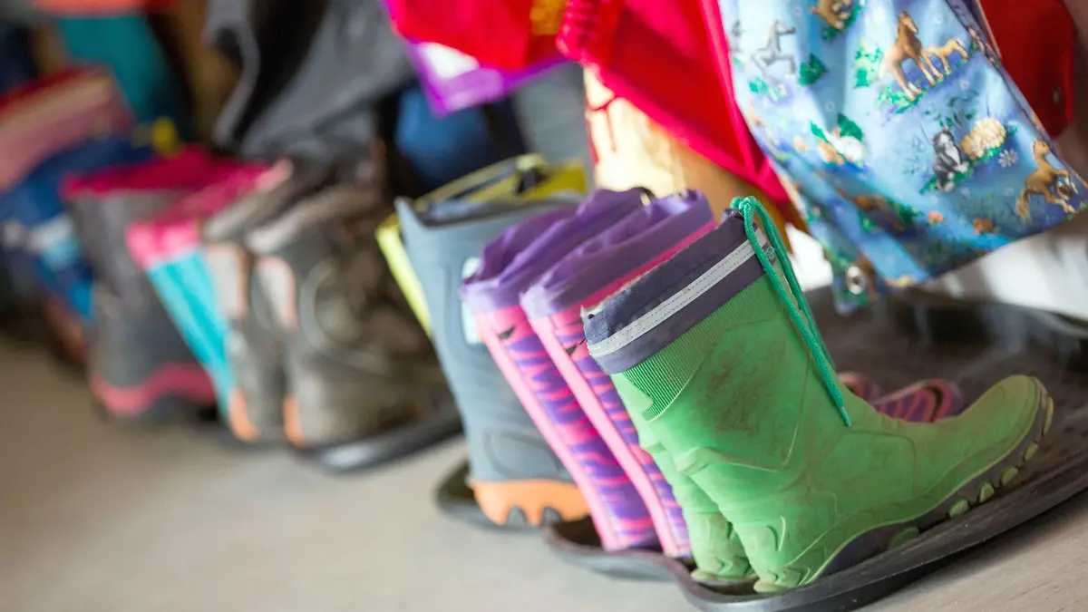 ARCHIV - 02.05.2016, Mecklenburg-Vorpommern, Rohlstorf: Gummistiefel für Kinder stehen in der Garderobe der Kindertagesstätte «Spatzenhaus». Nach Plänen von Sozialministerin Stefanie Drese (SPD) sollen die sogenannten Kita-Alltagshelfer in Mecklenburg-Vorpommern von 2022 an dauerhaft zum Einsatz kommen. (zu dpa "Sozialministerin plant dauerhaften Einsatz von Kita-Alltagshelfern") Foto: Jens Büttner/zb/dpa +++ dpa-Bildfunk +++