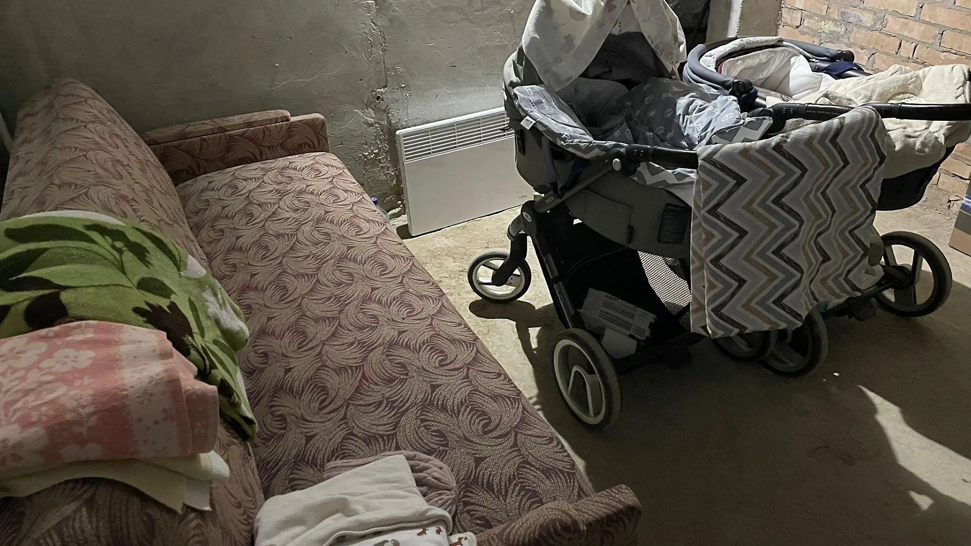In diesem Betonkeller in Kiew harrte die frischgebackene Familie nächtelang aus. Eine Elektroheizung, ein Sofa, wenige Decken - und ständig die Angst im Nacken, es nicht mehr nach Hause zu schaffen.
