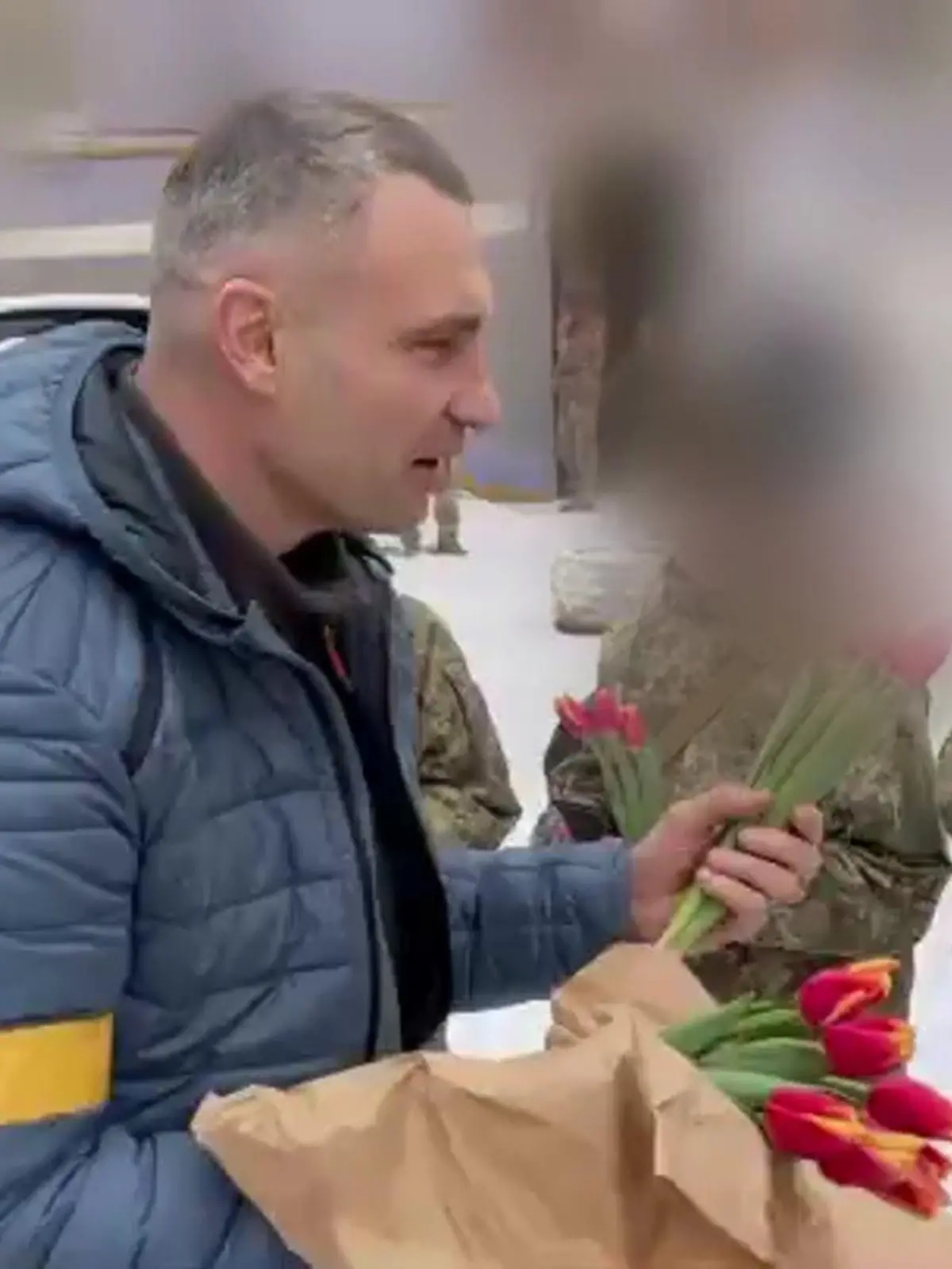 Vitali Klitschko, Bürgermeister der ukrainischen Hauptstadt Kiew, verteilt Tulpen an Soldatinnen.