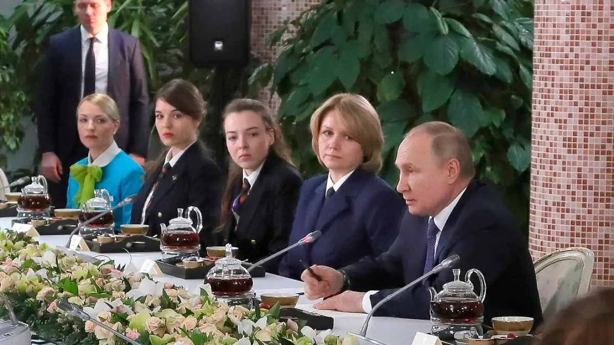 Russian President Vladimir Putin, center right, speaks to representatives of the flight crew of Russian airlines as he visits to Aeroflot Aviation School outside Moscow, Russia, Saturday, March 5, 2022. (, Sputnik, Kremlin Pool Photo via AP)