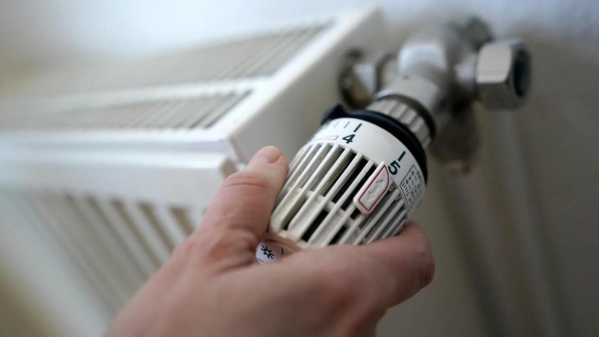 ARCHIV - 09.03.2022, Hamburg: ILLUSTRATION - Eine Frau dreht an einem Heizungsthermostat. Das umstrittene Gesetz zum Austausch alter Öl- und Gasheizungen sorgt weiter für Streit in der Ampel-Koalition. (zu dpa «Heizungsgesetz vorerst wieder nicht auf Bundestags-Tagesordnung») Foto: Marcus Brandt/dpa +++ dpa-Bildfunk +++