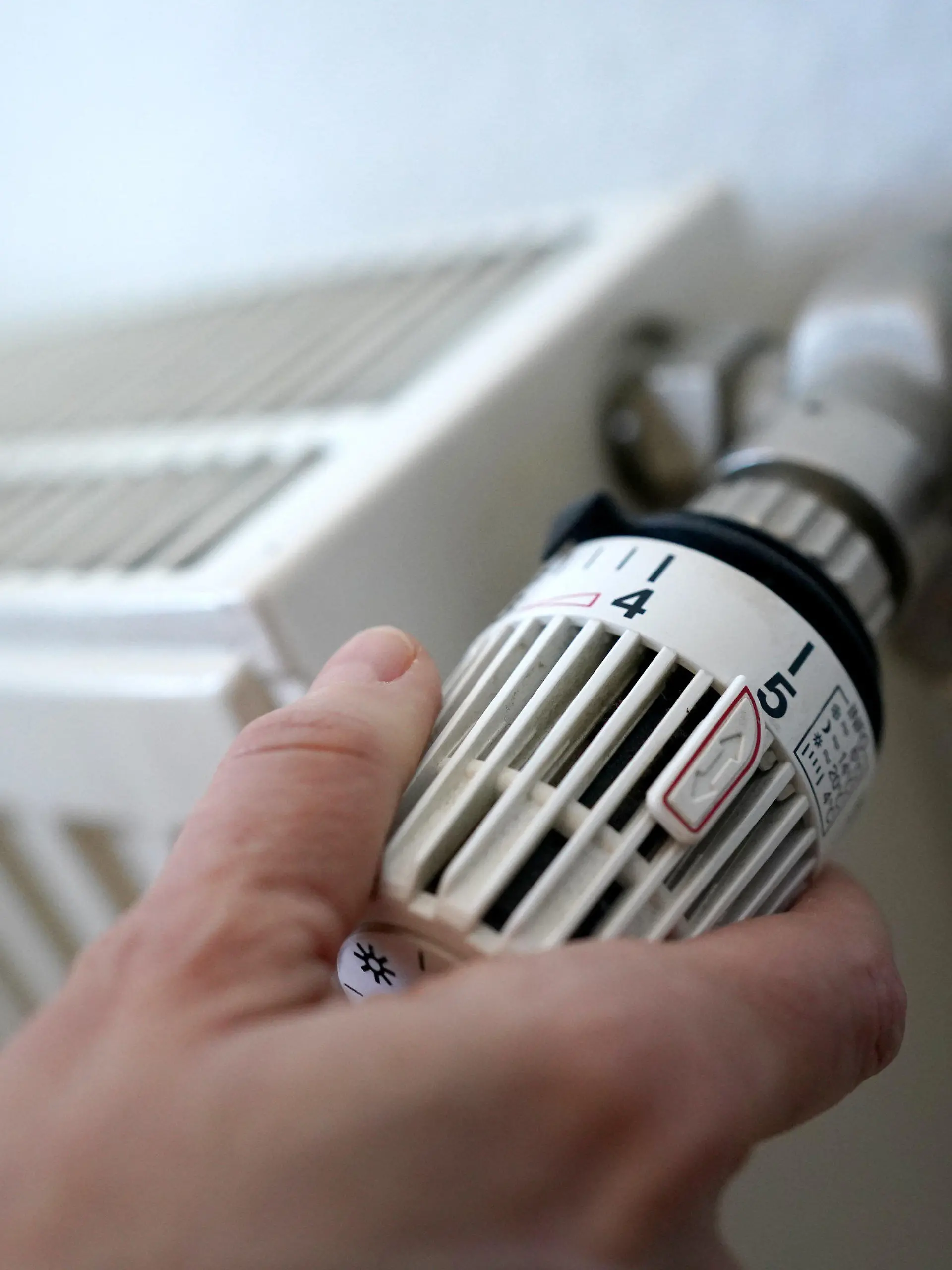 ARCHIV - 09.03.2022, Hamburg: ILLUSTRATION - Eine Frau dreht an einem Heizungsthermostat. Das umstrittene Gesetz zum Austausch alter Öl- und Gasheizungen sorgt weiter für Streit in der Ampel-Koalition. (zu dpa «Heizungsgesetz vorerst wieder nicht auf Bundestags-Tagesordnung») Foto: Marcus Brandt/dpa +++ dpa-Bildfunk +++
