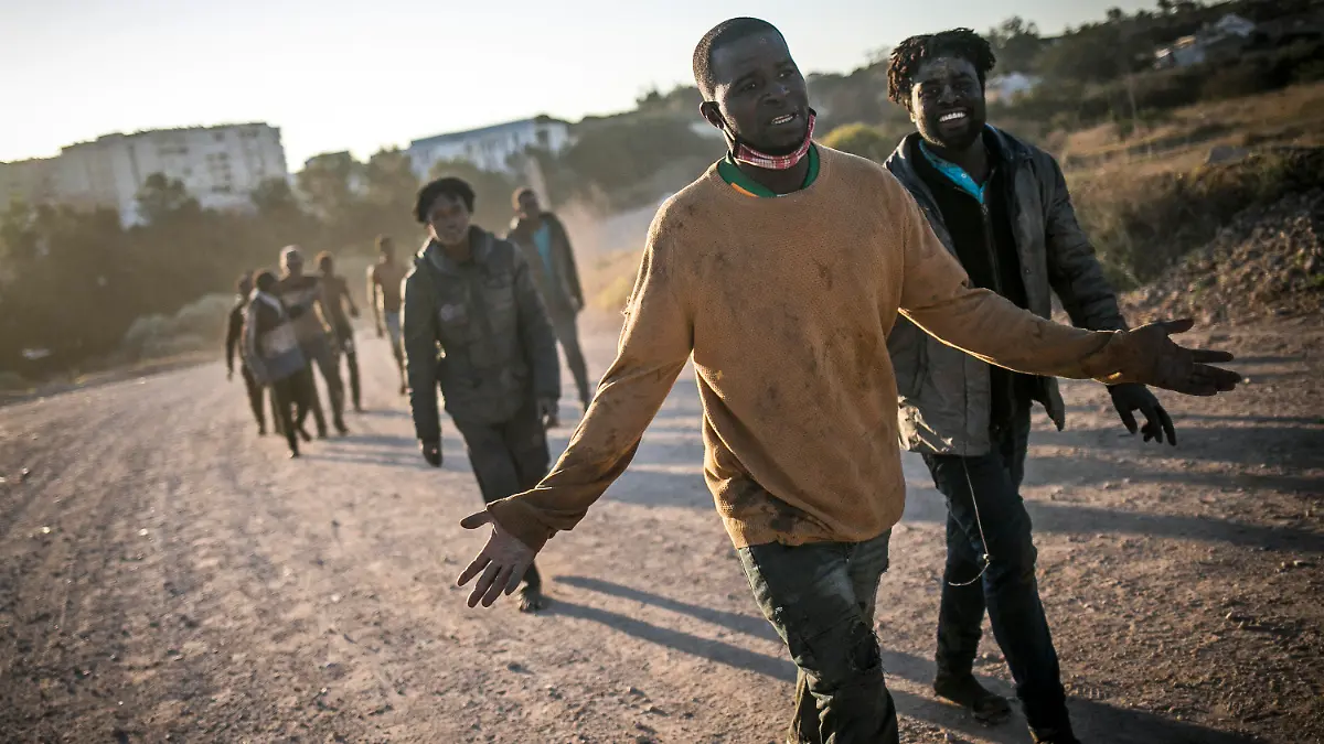 03.03.2022, Spanien, Melilla: Migranten gehen auf einem Weg entlang, nachdem sie sie die Zäune zwischen der spanischen autonomen Stadt Melilla in Nordafrika und Marokko überquert haben. Nach Angaben der Beamten in Melilla haben mehrere Hundert Migranten die Zäune überquert, die Melilla von Marokko trennen. Foto: Javier Bernardo/AP/dpa +++ dpa-Bildfunk +++
