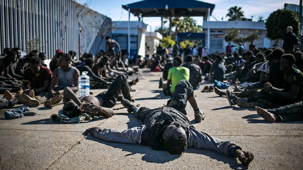 02.03.2022, Spanien, Melilla: Migranten ruhen sich in einem Auffanglager aus, nachdem sie die Zäune zwischen der spanischen autonomen Stadt Melilla in Nordafrika und Marokko überquert haben. Nach Angaben der Beamten in Melilla haben mindestens 500 Migranten die Zäune überquert, die Melilla von Marokko trennen. Foto: Javier Bernardo/AP/dpa +++ dpa-Bildfunk +++