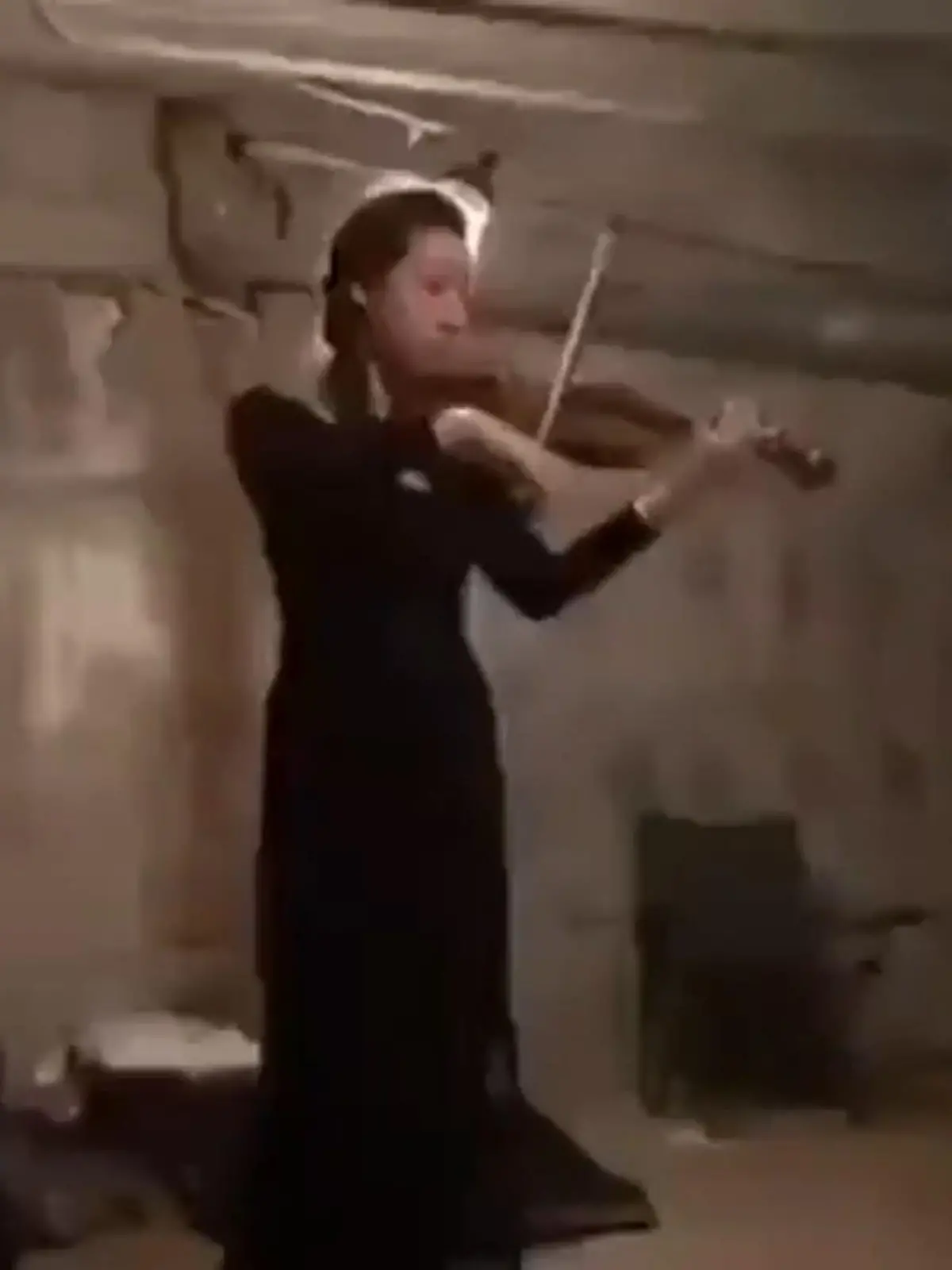 Eine junge Frau schenkt ihren Mitmenschen im Luftschutzbunker einen Moment der Hoffnung.