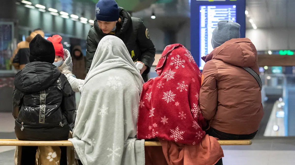 06.03.2022, Berlin: In Decken gehüllt sitzen diese Kinder aus dem ukrainischen Kriegsgebiet im Berliner Hauptbahnhof, während sich ein ehrenamtlicher Helfer um die Kinder kümmert. Auch an diesem Morgen sind bereits zahlreiche Flüchtlinge aus dem Kriegsgebiet in Berlin angekommen. Russische Truppen marschierten am 24. Februar in die Ukraine ein. Foto: Paul Zinken/dpa +++ dpa-Bildfunk +++