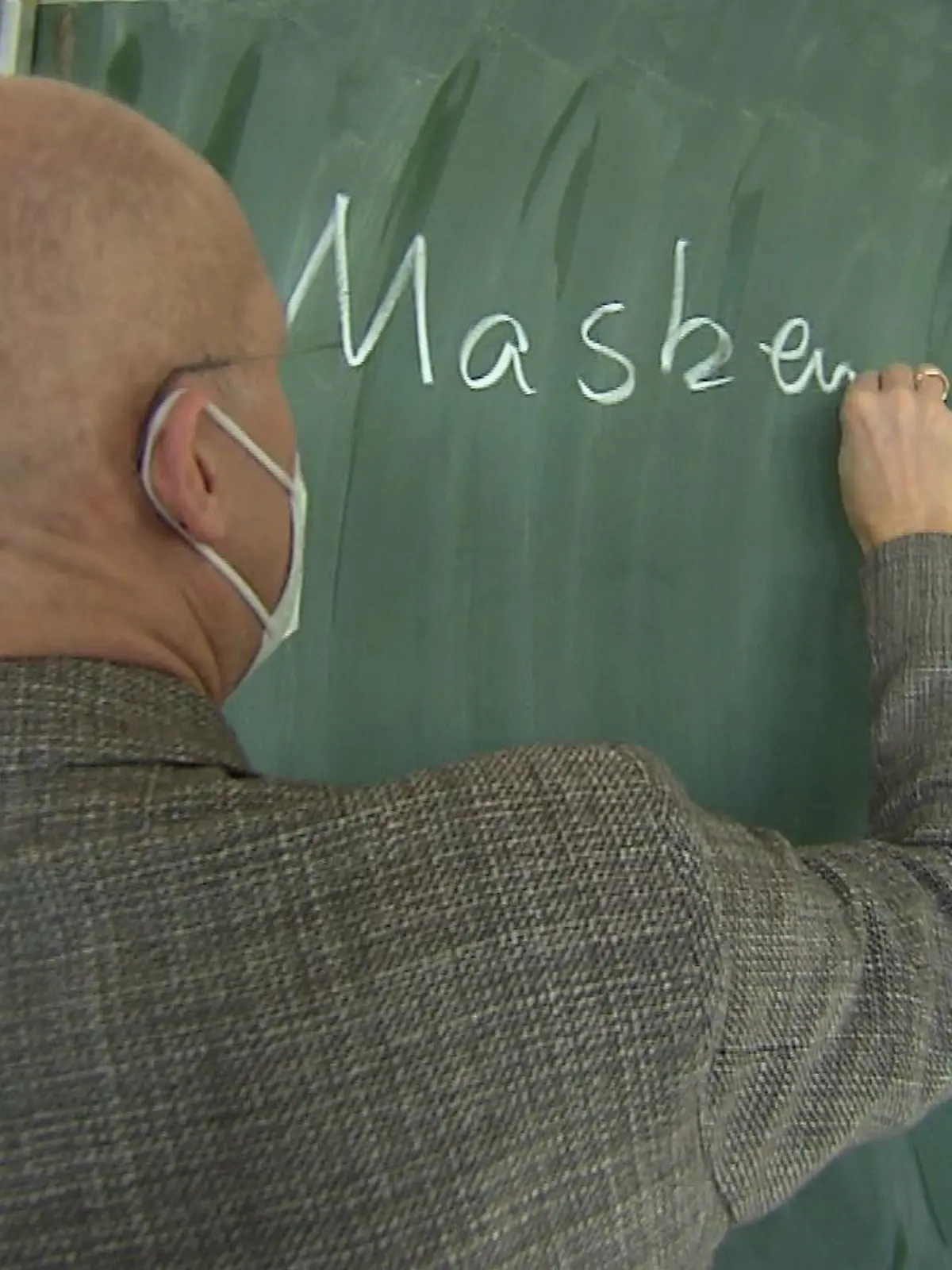 Schulleiter Gerrit Ulmke schreibt "Maske" an eine Tafel am Helmholtz-Gymnasium in Frankfurt.