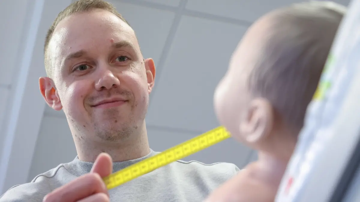 PRODUKTION - 23.02.2022, Nordrhein-Westfalen, Bielefeld: Jonas Küppers, männliche Hebamme, vermisst in einer gestellten Situation den Kopfumfang einer Neugeborenen-Übungspuppe. Küppers absolviert ein duales Studium, um den Beruf der Hebamme zu lernen. In Deutschland sind Männer im Hebammen-Beruf extrem selten. (zu dpa: «Als Mann im Frauen-Beruf Hebamme - im Kreißsaal eine extreme Ausnahme») Foto: Friso Gentsch/dpa +++ dpa-Bildfunk +++