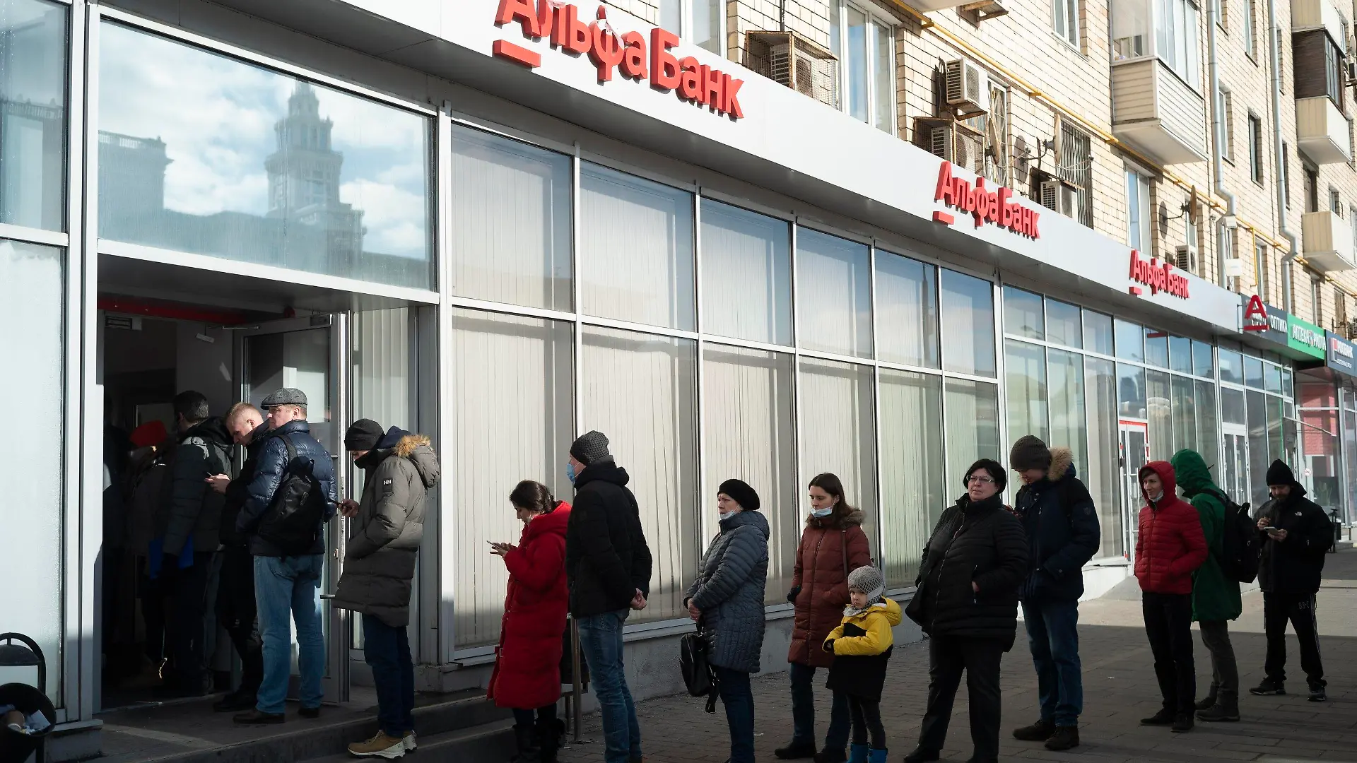 27.02.2022, Russland, Moskau: Menschen stehen in einer Schlange, um Geld von einem Geldautomaten der Alfa Bank abzuheben. Russische Truppen haben den erwarteten Angriff auf die Ukraine gestartet. Foto: Victor Berzkin/AP/dpa +++ dpa-Bildfunk +++
