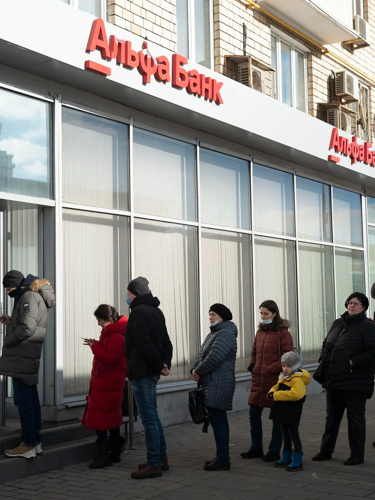 27.02.2022, Russland, Moskau: Menschen stehen in einer Schlange, um Geld von einem Geldautomaten der Alfa Bank abzuheben.  Russische Truppen haben den erwarteten Angriff auf die Ukraine gestartet. Foto: Victor Berzkin/AP/dpa +++ dpa-Bildfunk +++