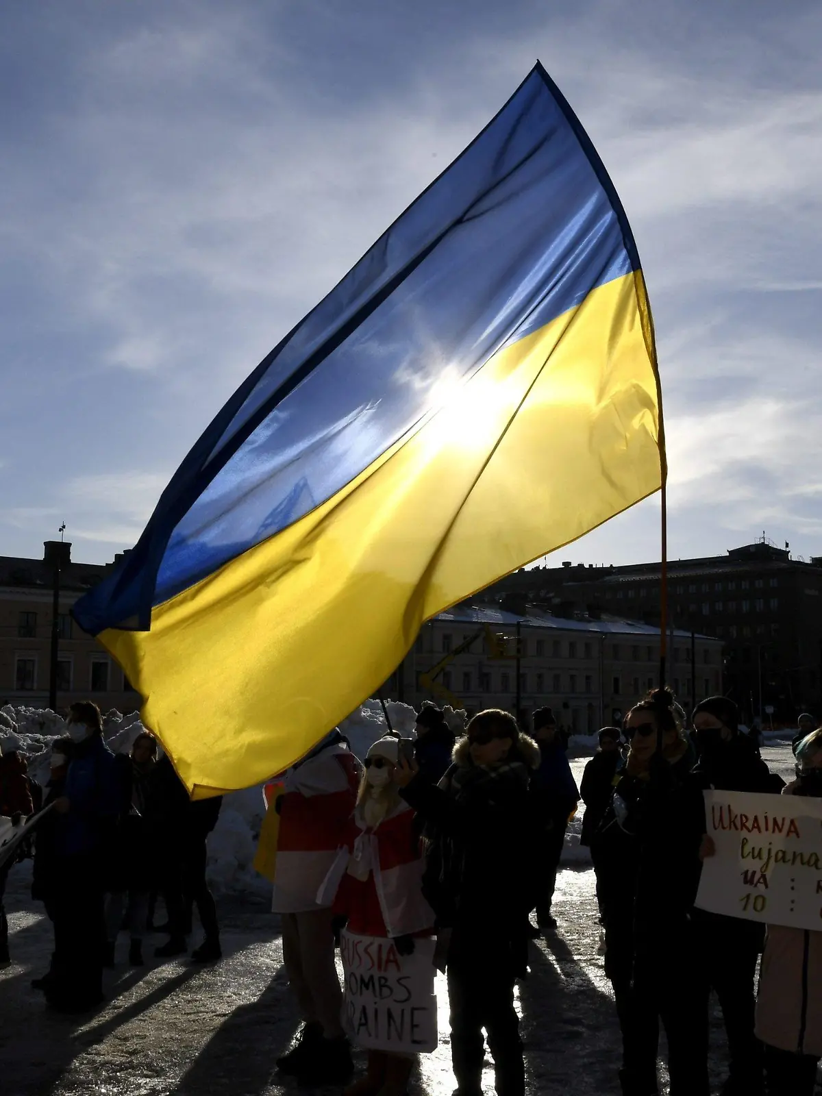 27.02.2022, Finnland, Helsinki: Teilnehmer einer Demonstration halten eine ukrainische Fahne bei einem Protest gegen die Invasion in die Ukraine. Russlands Nachbar Finnland will seine militärische Abwehr wegen der Entwicklungen in der Ukraine mit Waffensystemen aus Israel stärken. Foto: Jussi Nukari/Lehtikuva/dpa +++ dpa-Bildfunk +++